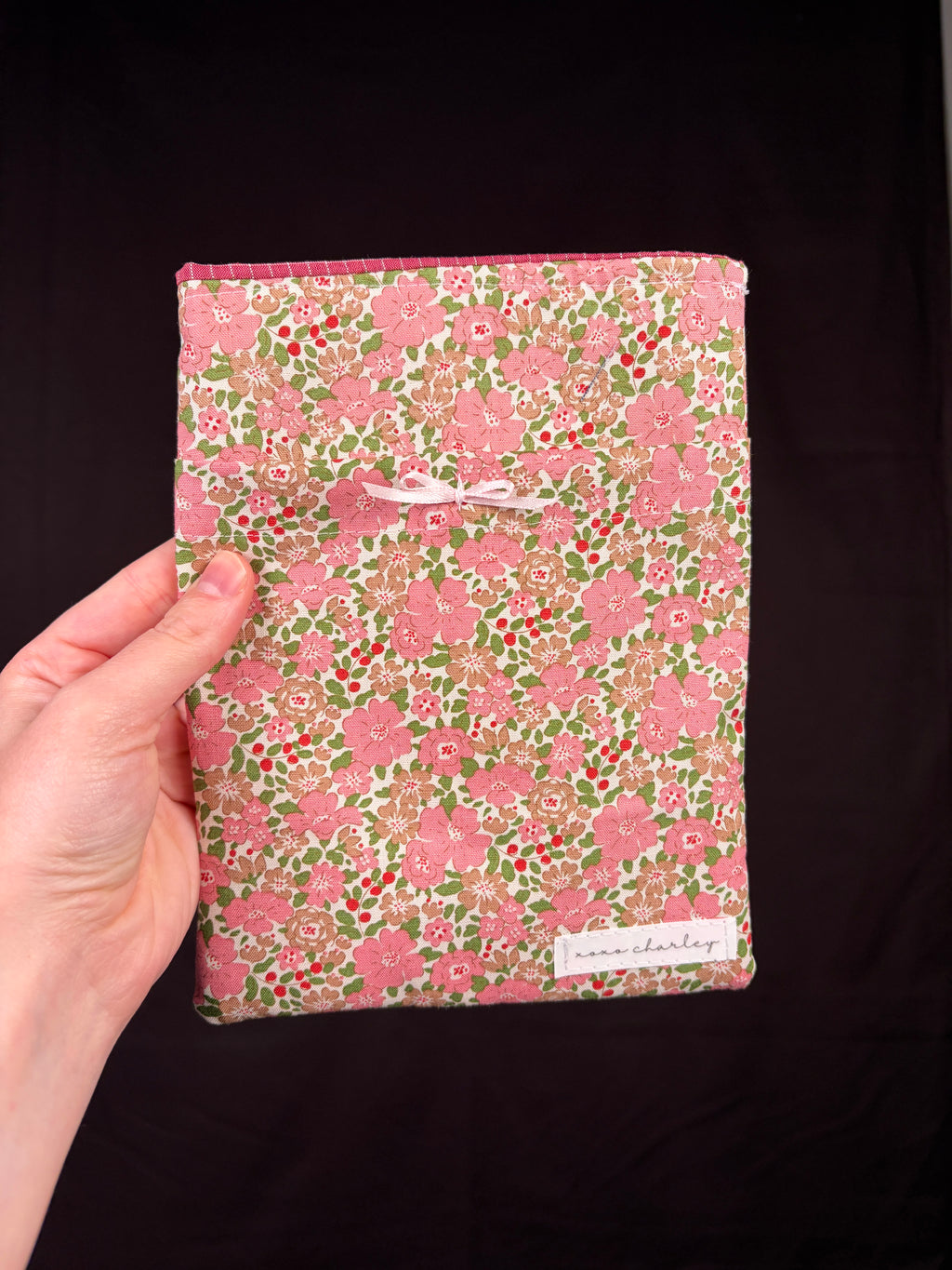 Floral e-reader sleeve in pink and green with white accents, rectangular fabric case
