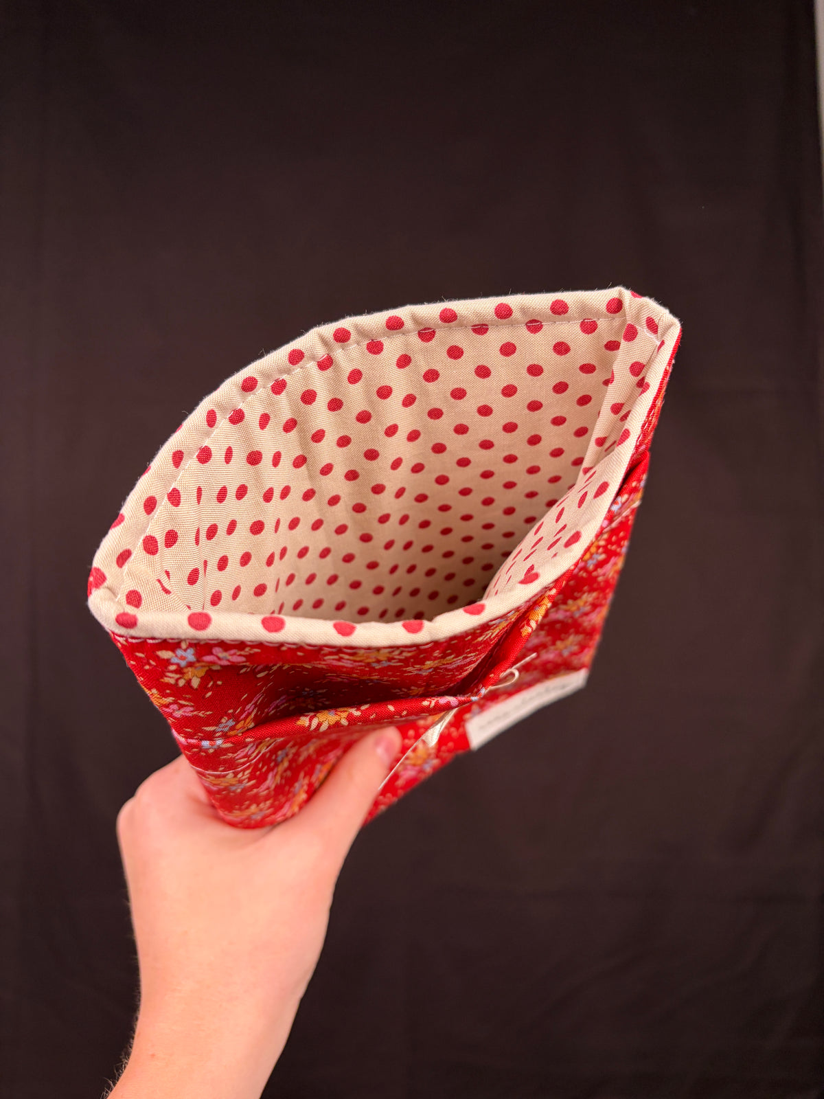 Red e-reader sleeve with white polka-dot lining visible from folded opening