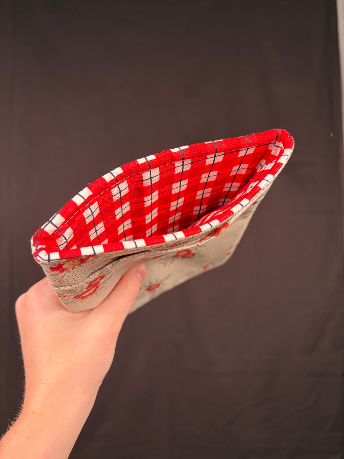 Floral e-reader sleeve with red plaid lining visible on open edge