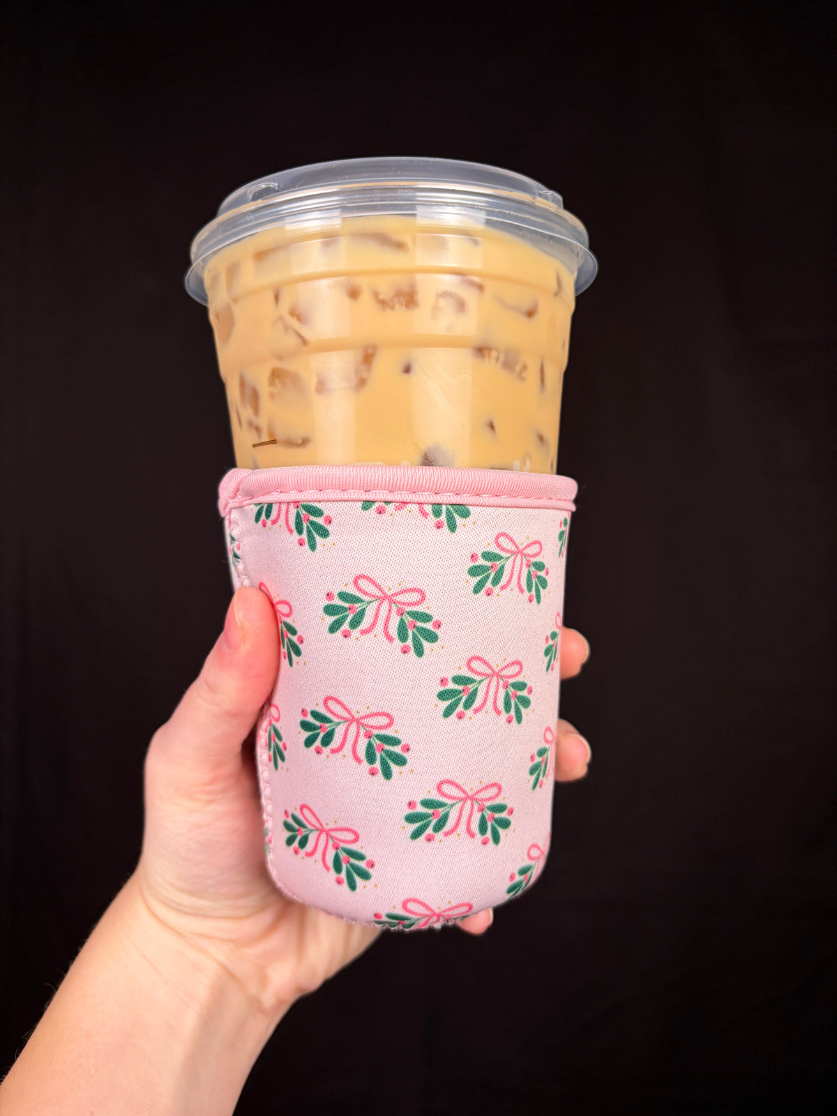 Small holiday cup sleeve with pink trim and green/red floral pattern