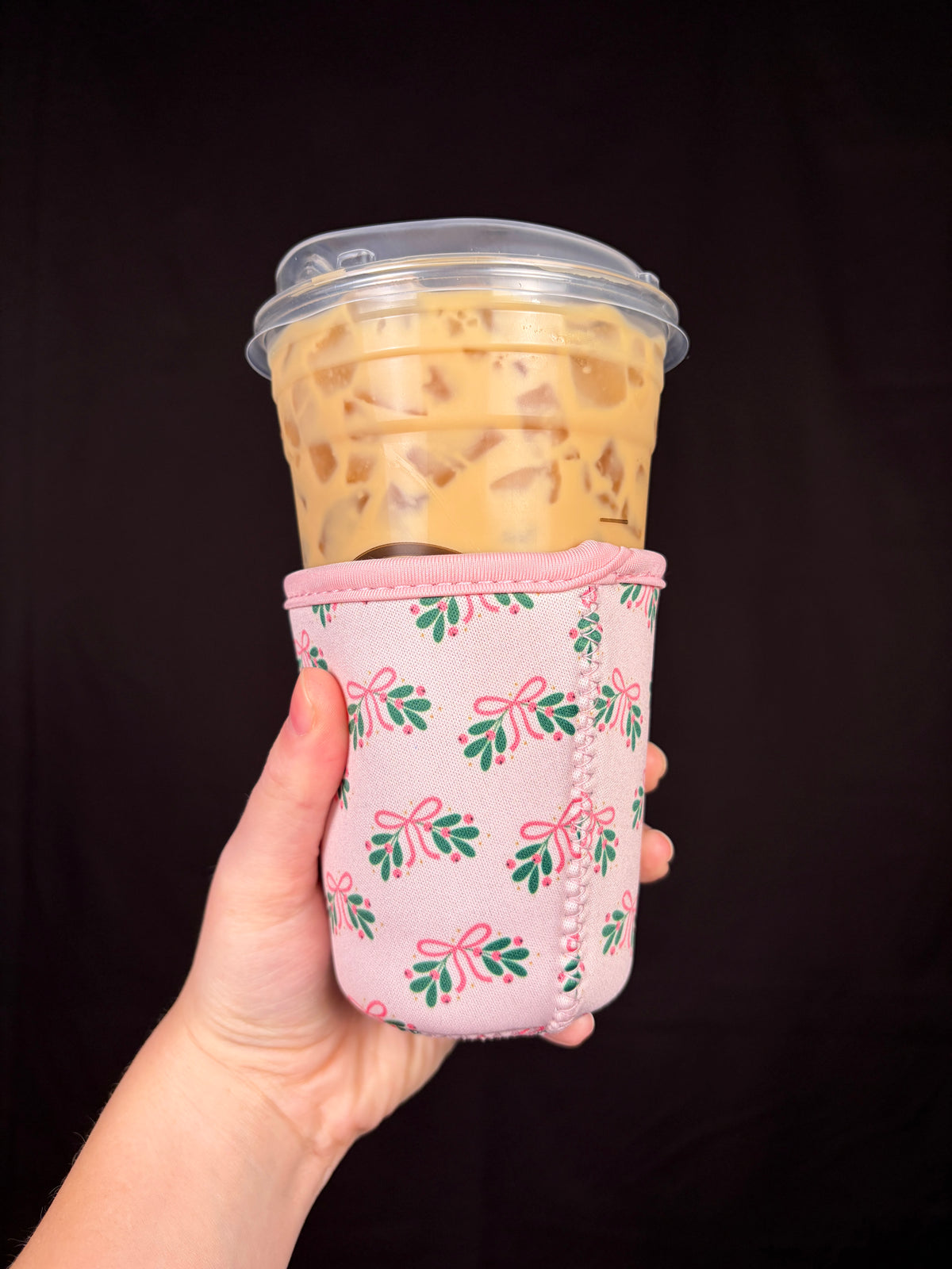 Small holiday cup sleeve wrapped on a clear cup, pink trim with floral pattern