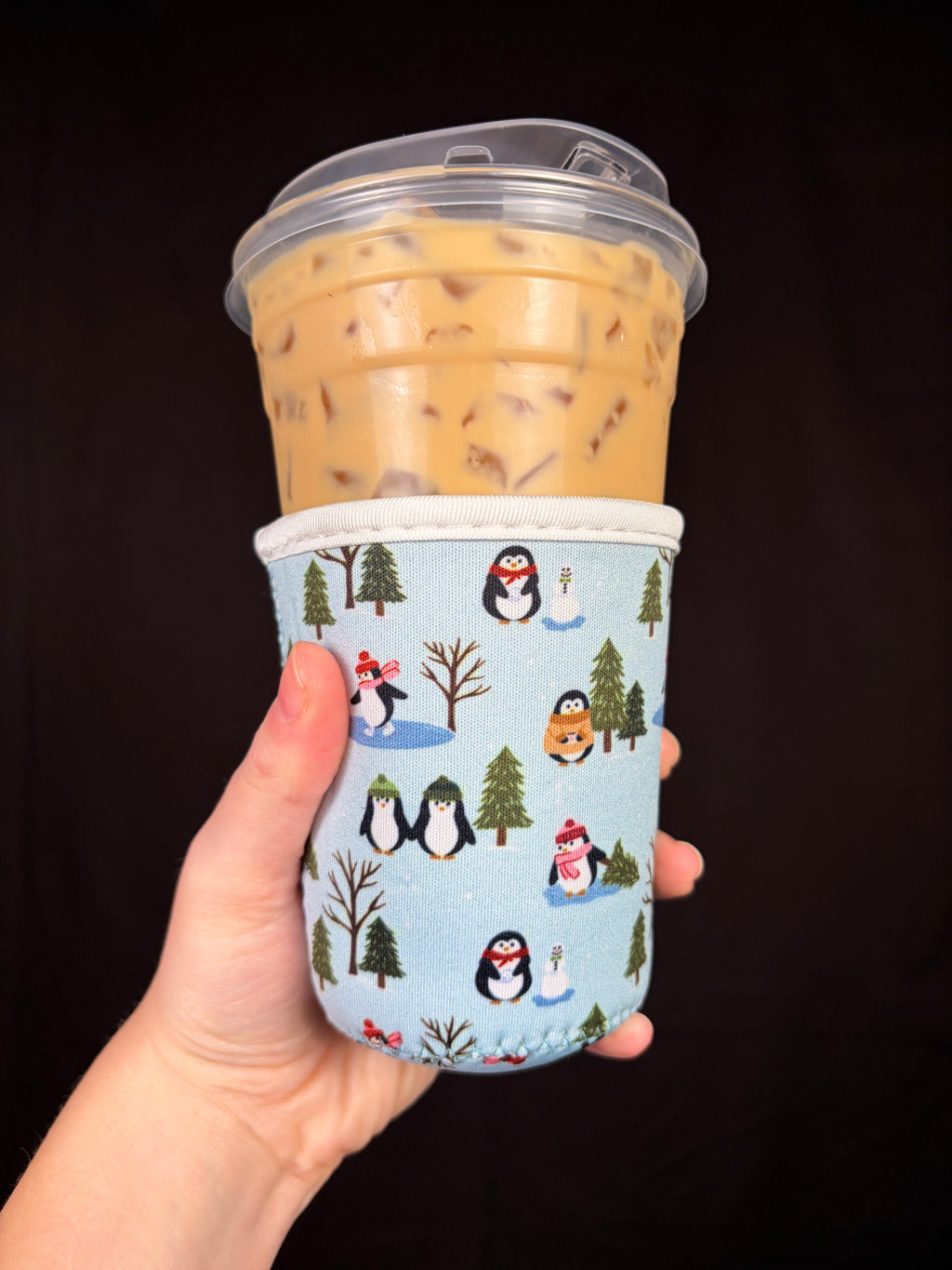 Small cup sleeve with penguin, trees, and winter village print