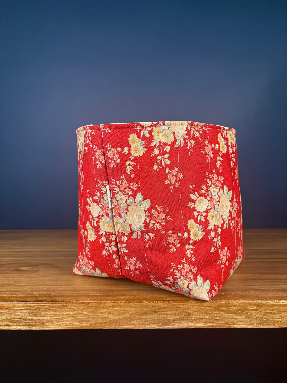 Large fabric bowl with red floral print, angled side view