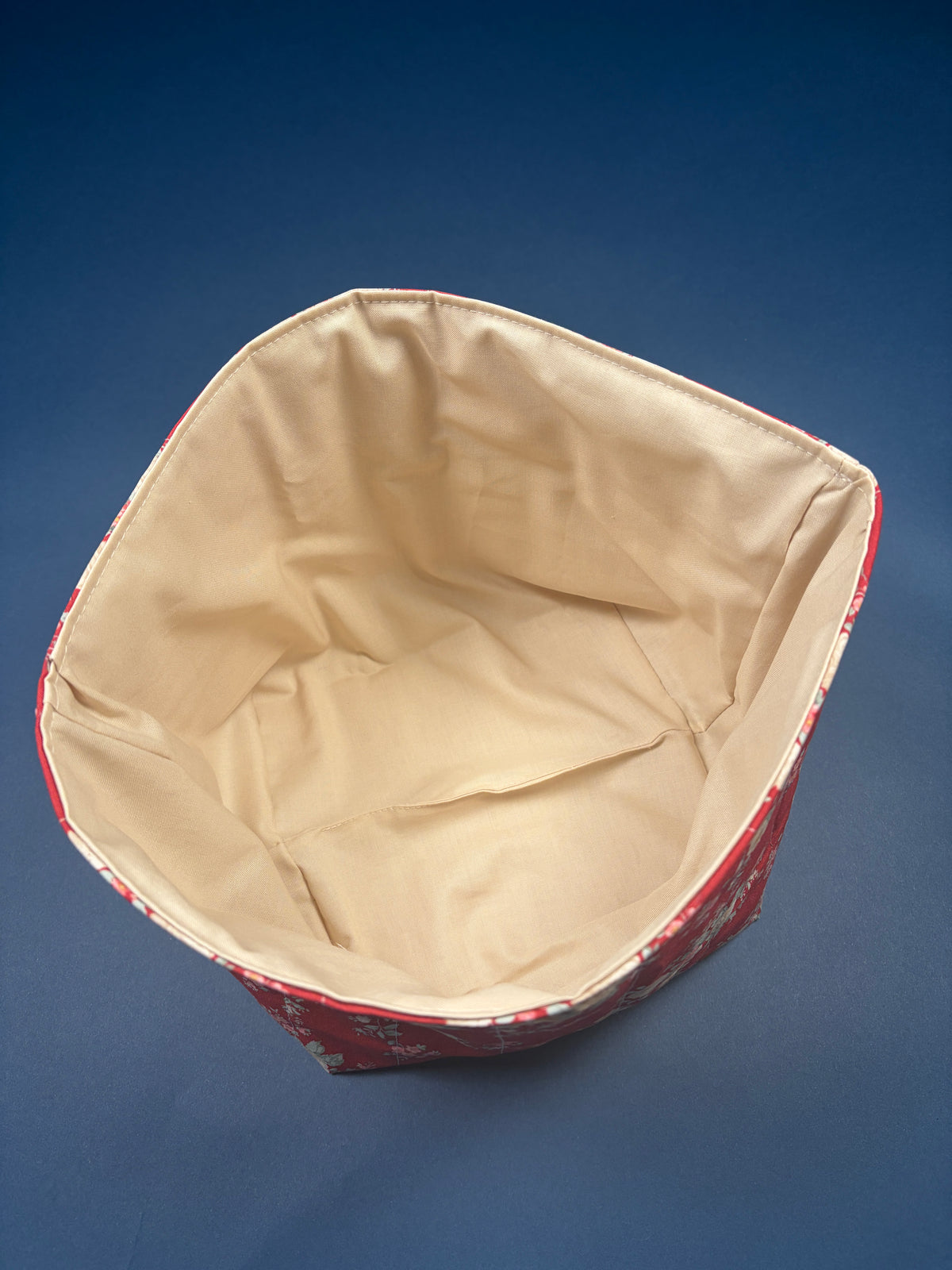 Large fabric bowl interior with cream lining and red floral rim