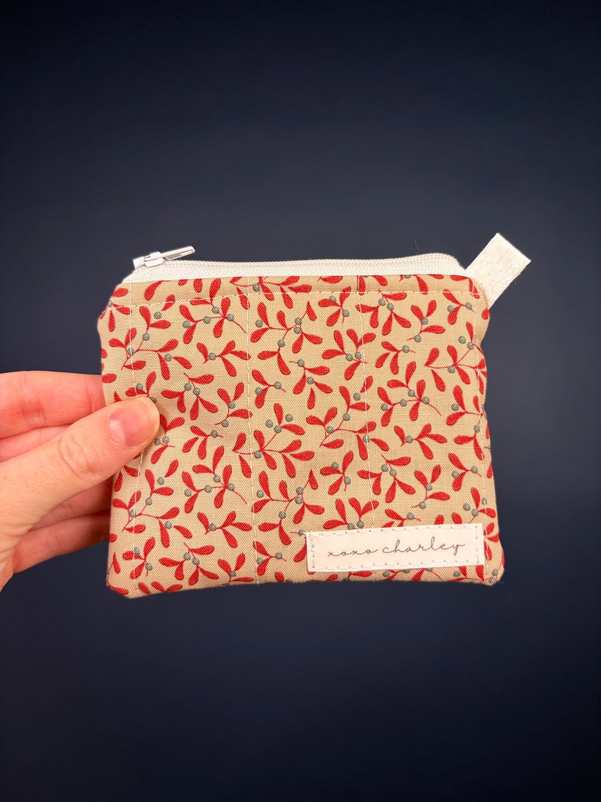 Leaf-print keychain wallet pouch in red and cream, zippered top with fabric tag