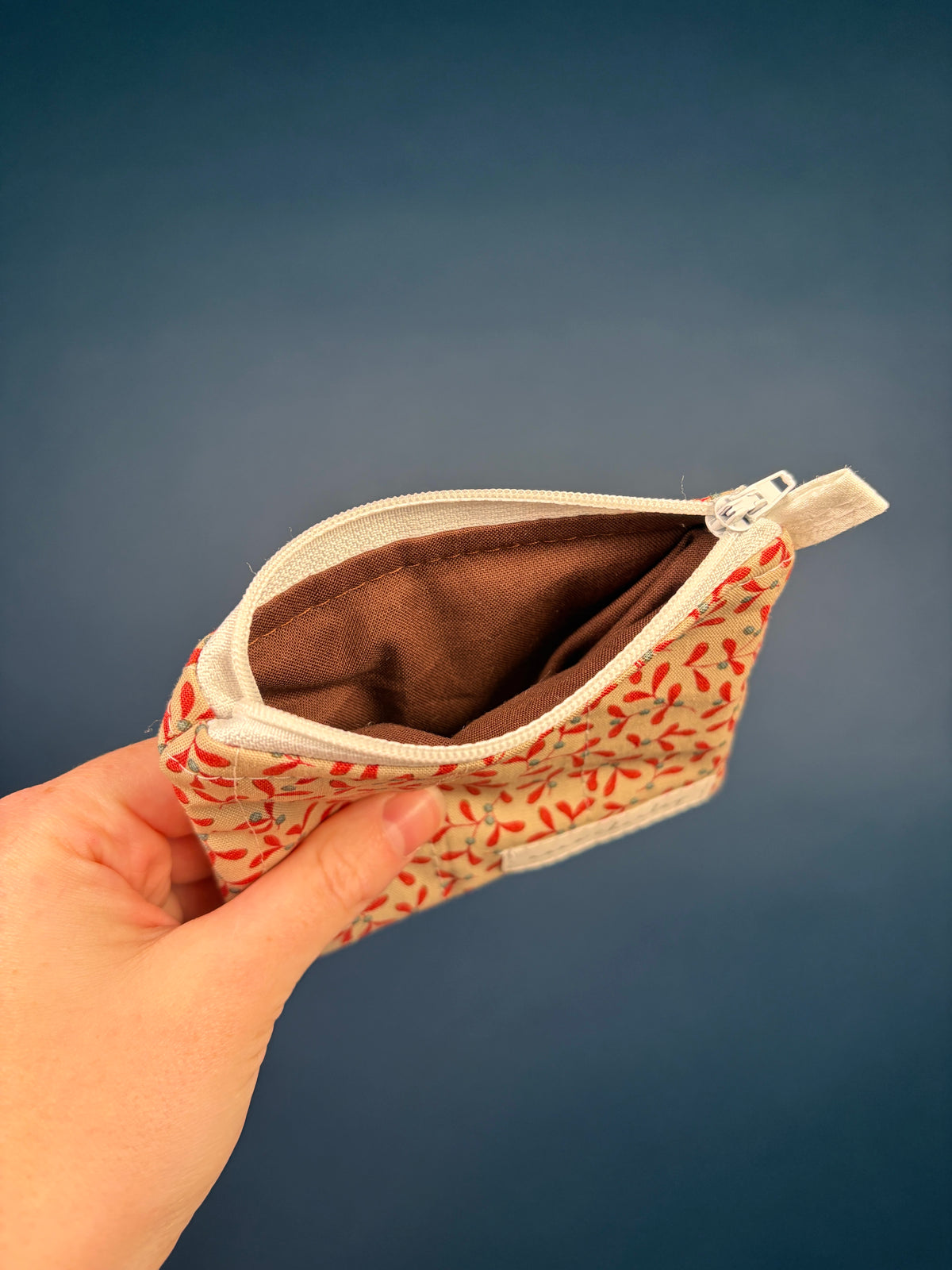 Red and cream leaf-pattern keychain wallet pouch opened, brown interior lining