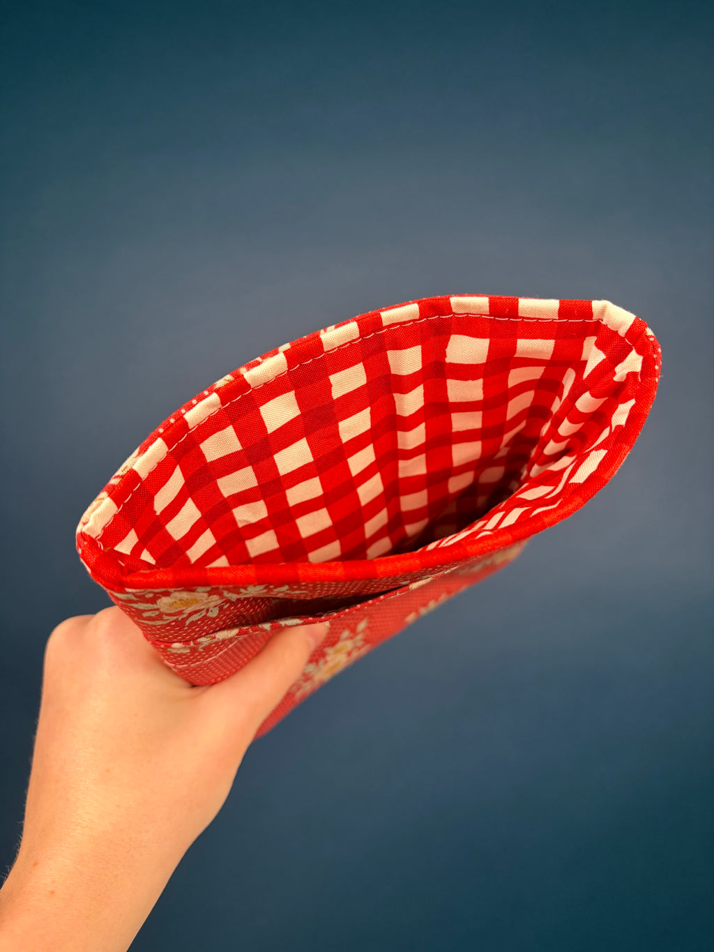 Red e-reader sleeve interior with red-and-white checkered lining and ribbon edge