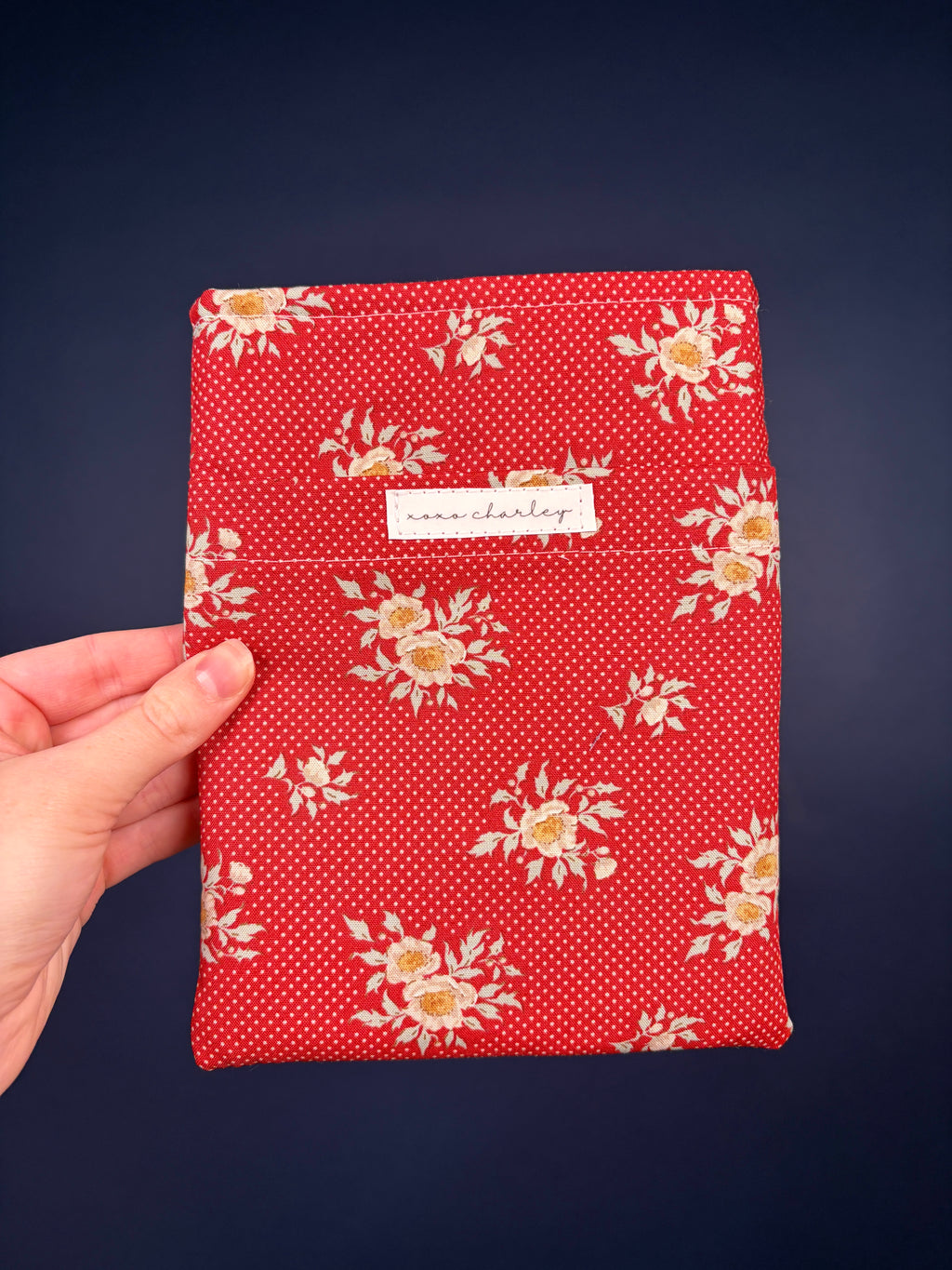 Red floral e-reader sleeve with dotted pattern and fabric label patch