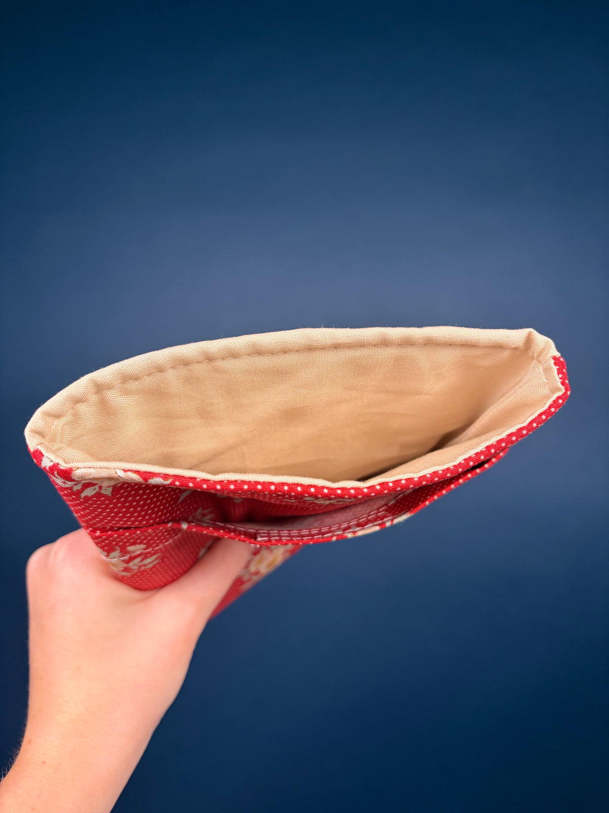 E-reader sleeve interior view with beige lining and red patterned border