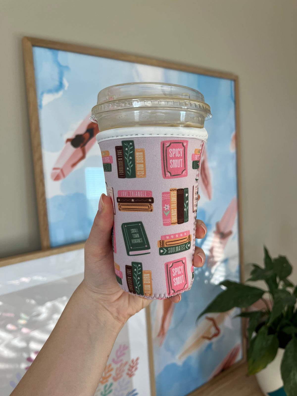 Book-spine printed cup sleeve in pink, green, and red with label-style blocks