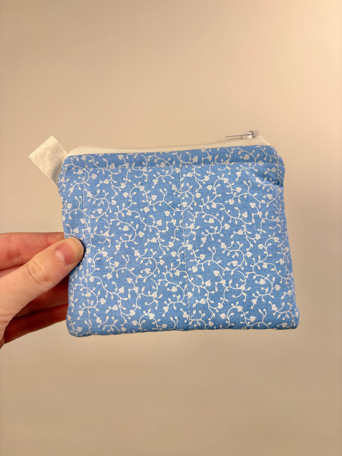 Blue keychain wallet with tiny white hearts, top zip and metal ring