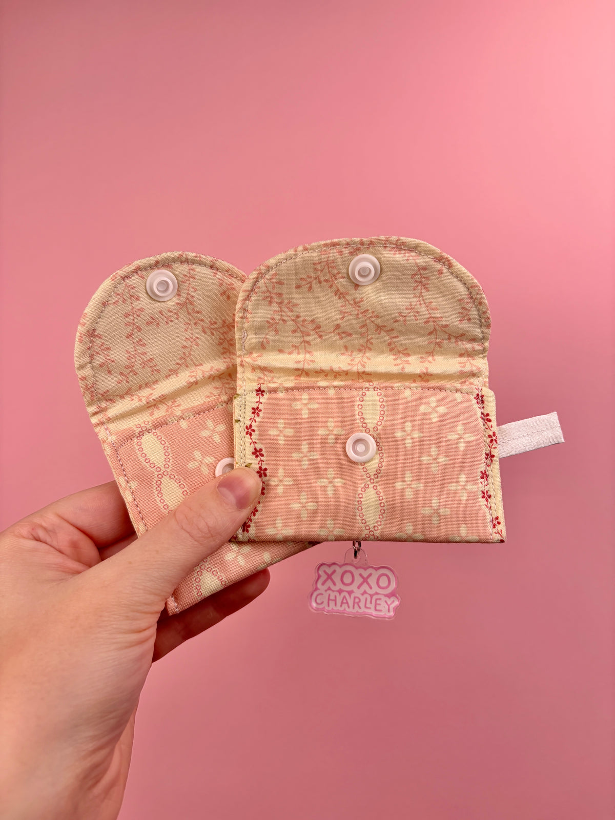 Floral earbuds case with foldover pouch, snap buttons, and keyring clips