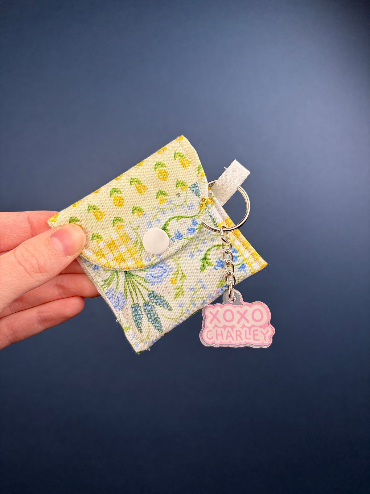 Patchwork earbuds case with leaf print and blue floral panel, keyring and pink charm.