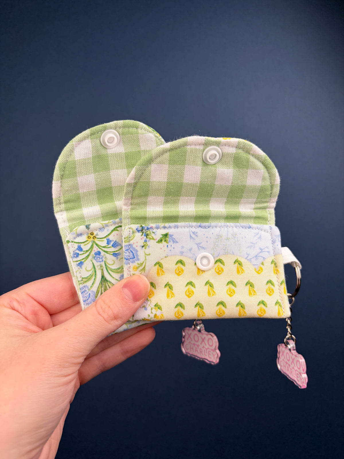 Patchwork earbuds case with green gingham flap, blue floral band, snap buttons and keyring.