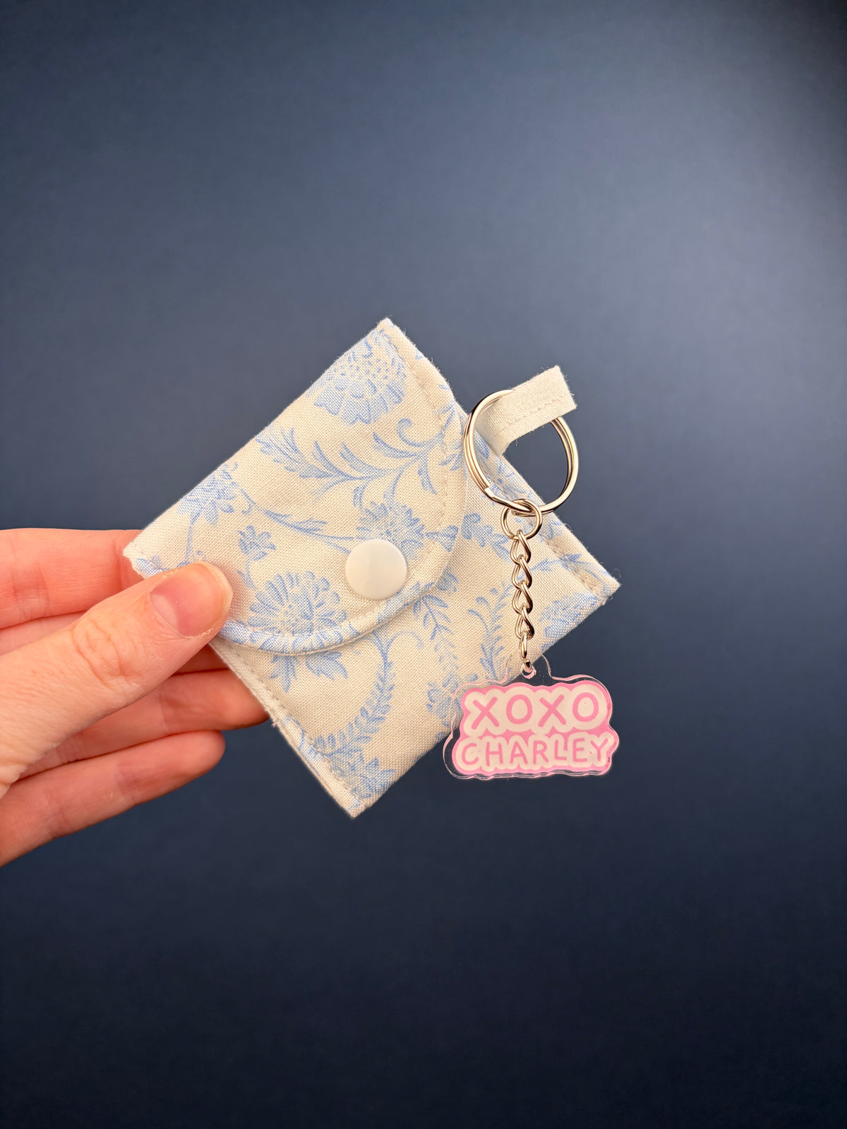 Blue floral earbuds case with snap top and chain keyring, XOXO charm logo