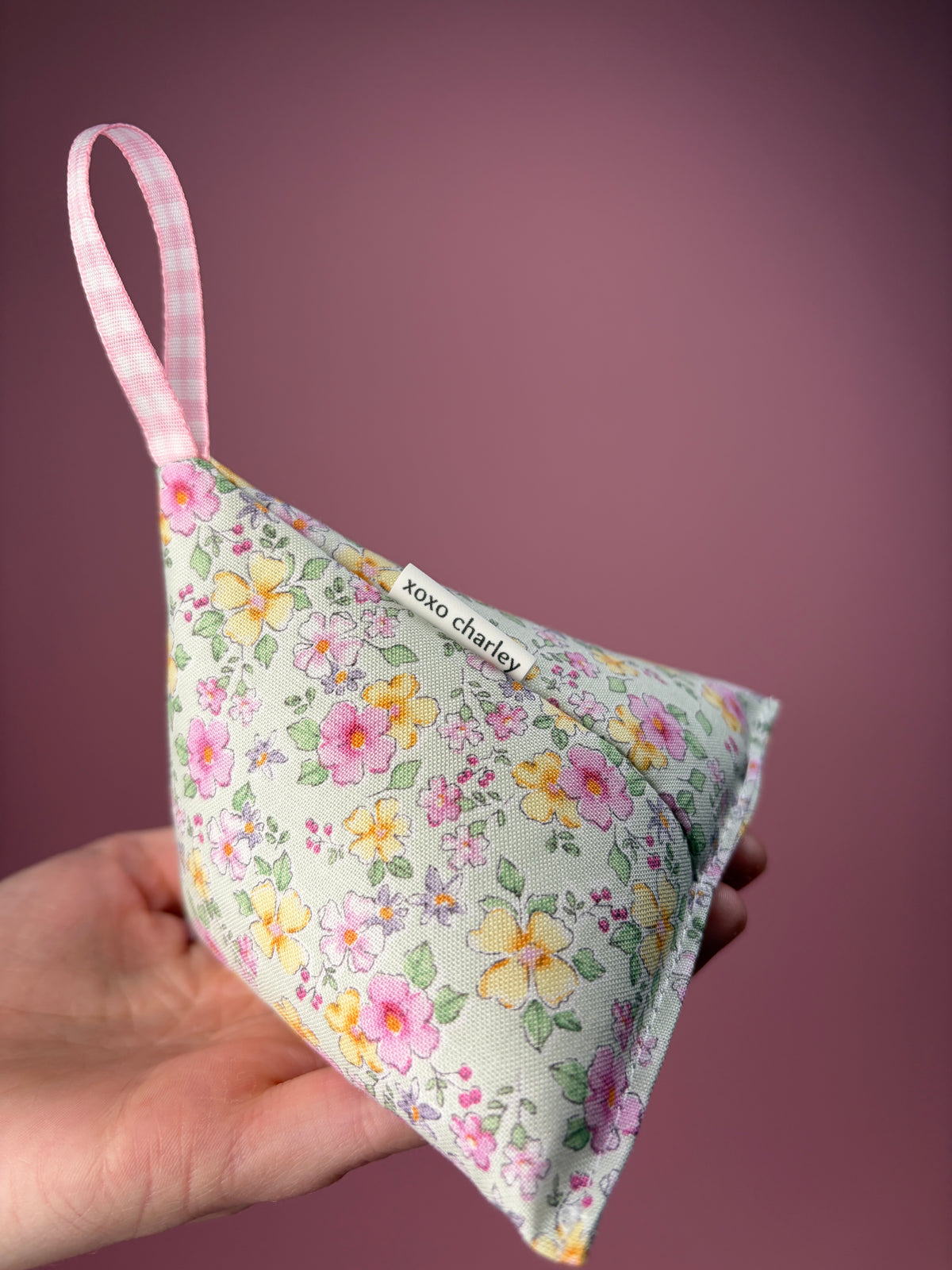 Floral fabric weight with pink ribbon and 'xoxo charley' label