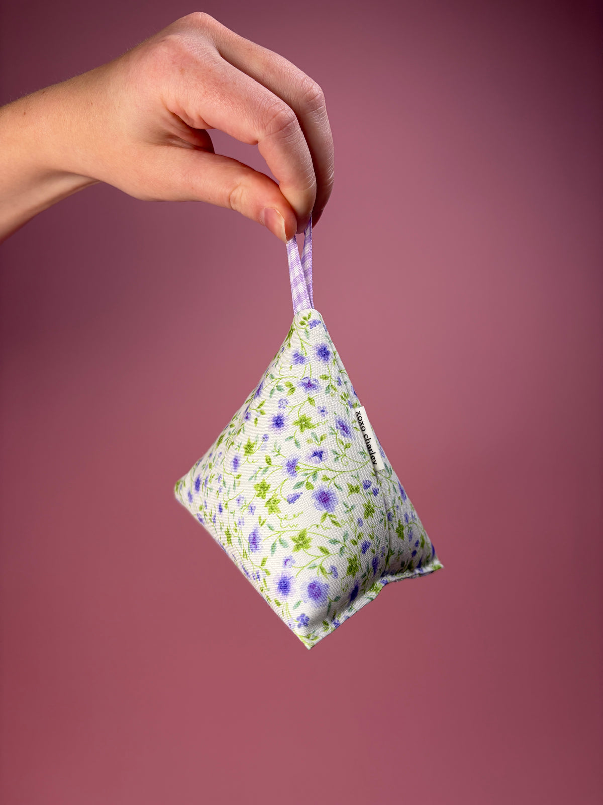 Floral-patterned weight with blue gingham ribbon loop, purple and green flowers