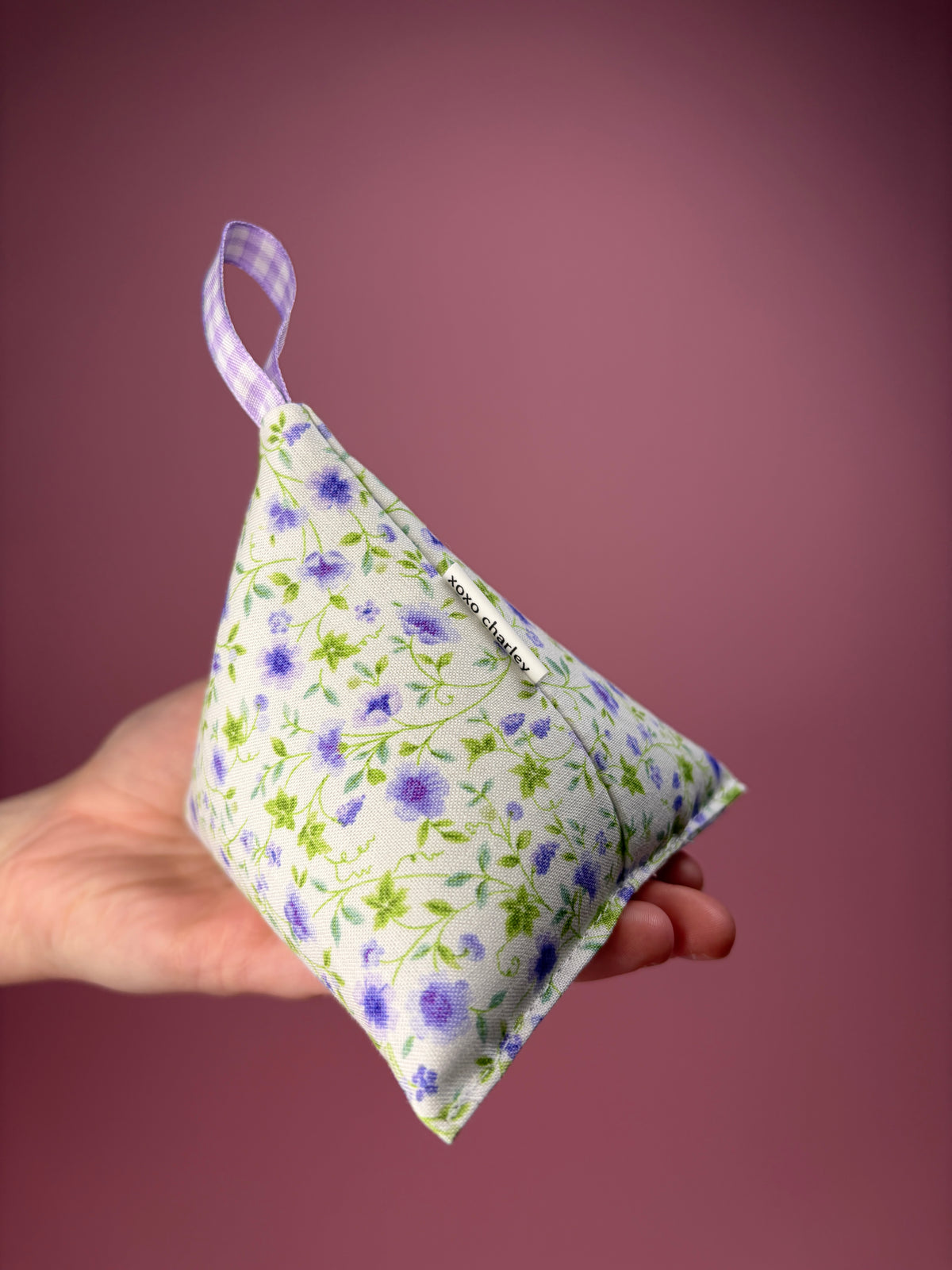 Floral-patterned weight with blue gingham ribbon loop and purple floral detail