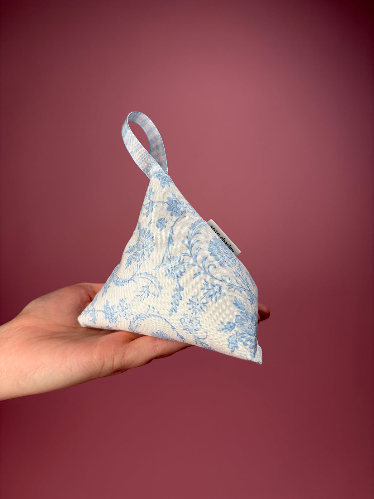 Vintage blue pattern weight: triangular blue floral pouch held in hand