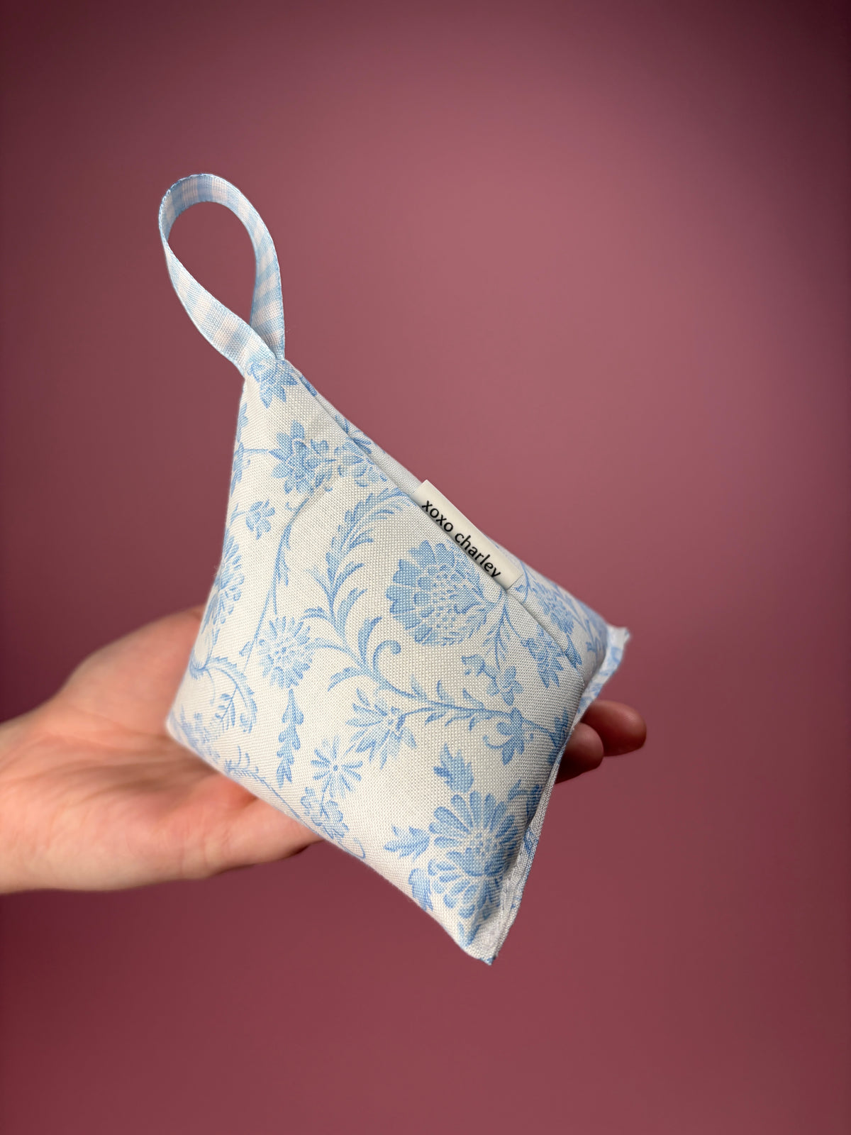 Vintage blue pattern weight: side view of triangular blue floral pouch with ribbon loop
