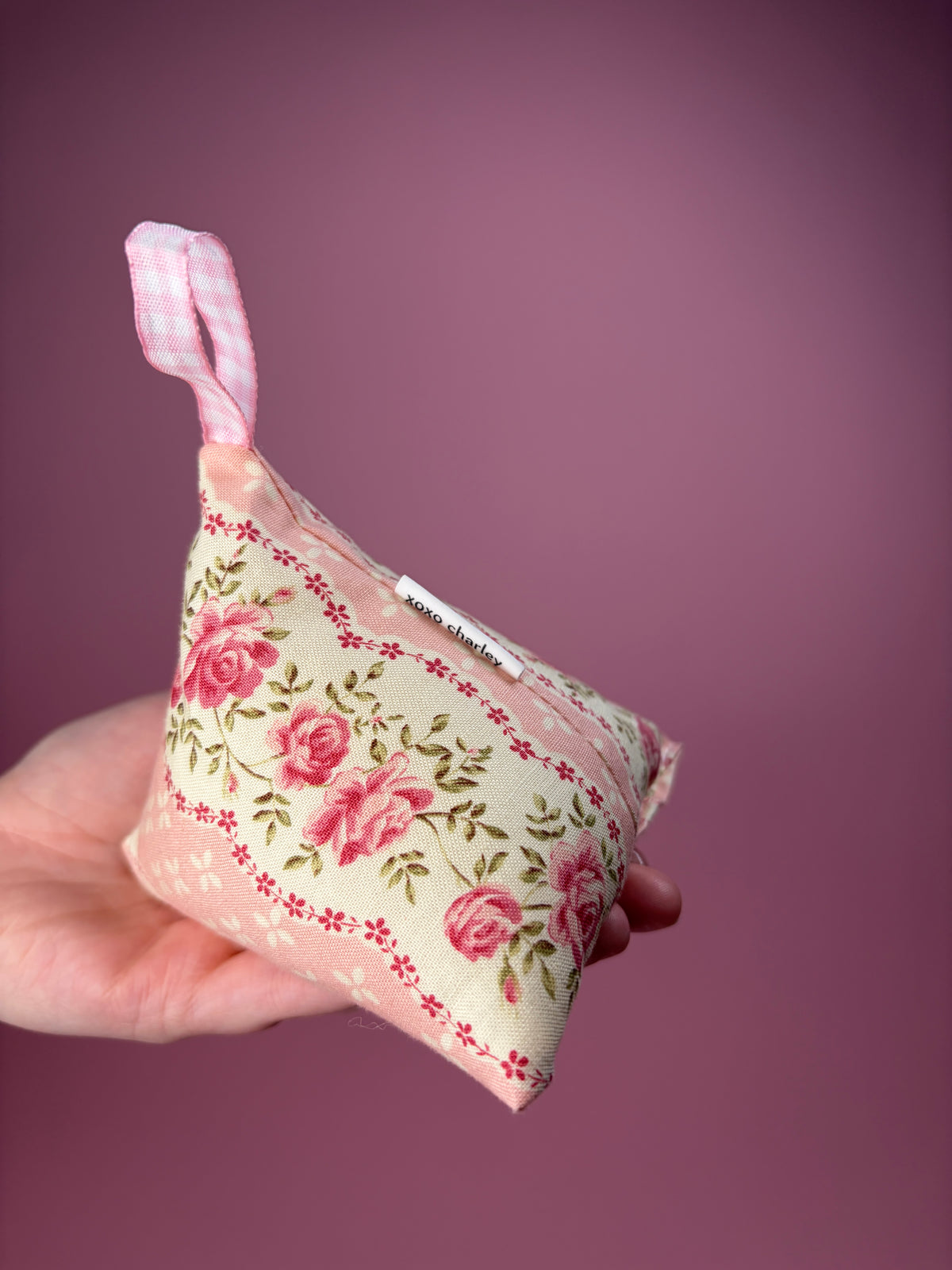 Floral fabric hanging weight pouch with pink ribbon loop and side label