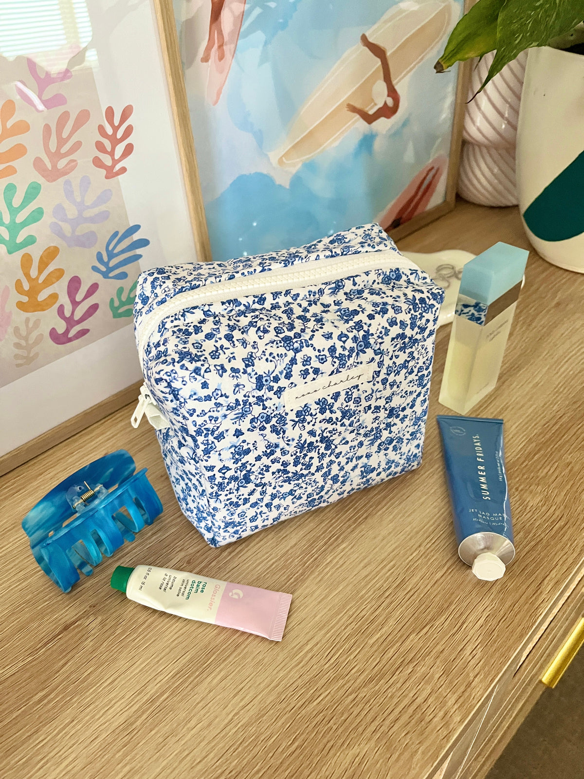 Medium makeup bag with blue floral print and white zipper trim