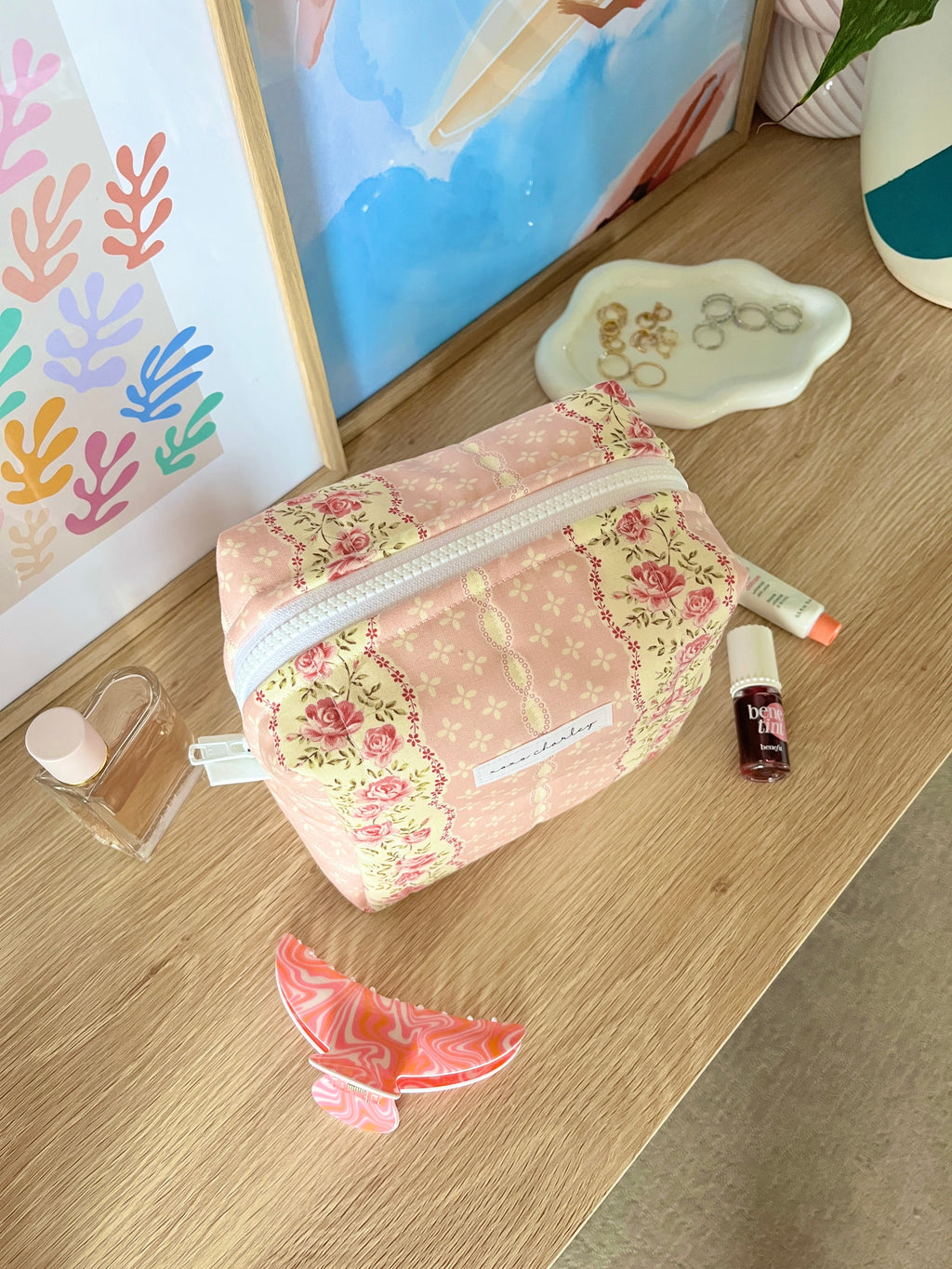 Pink floral medium makeup bag with silver zipper and white border