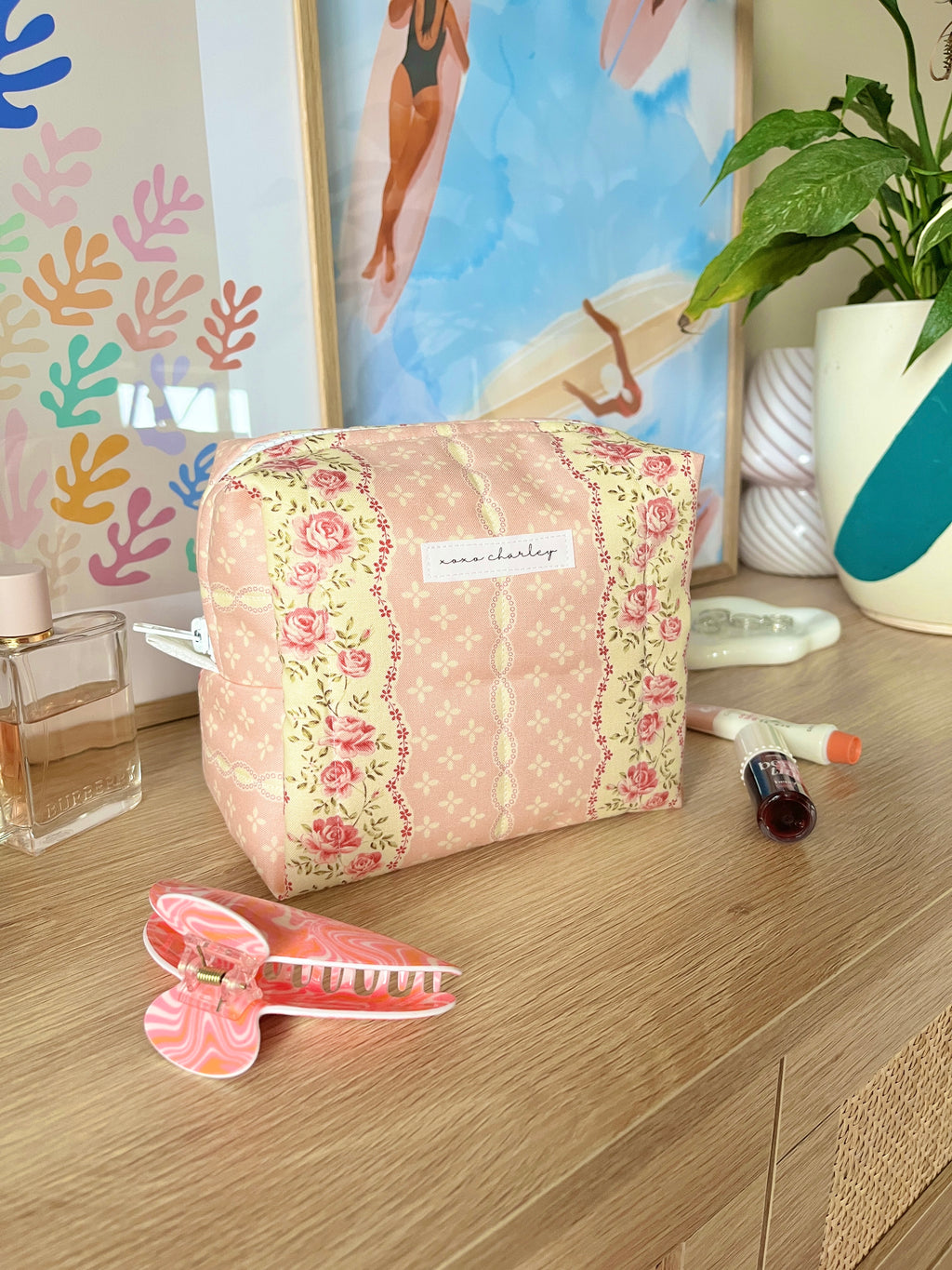 Pink floral medium makeup bag, rounded top with white zipper trim