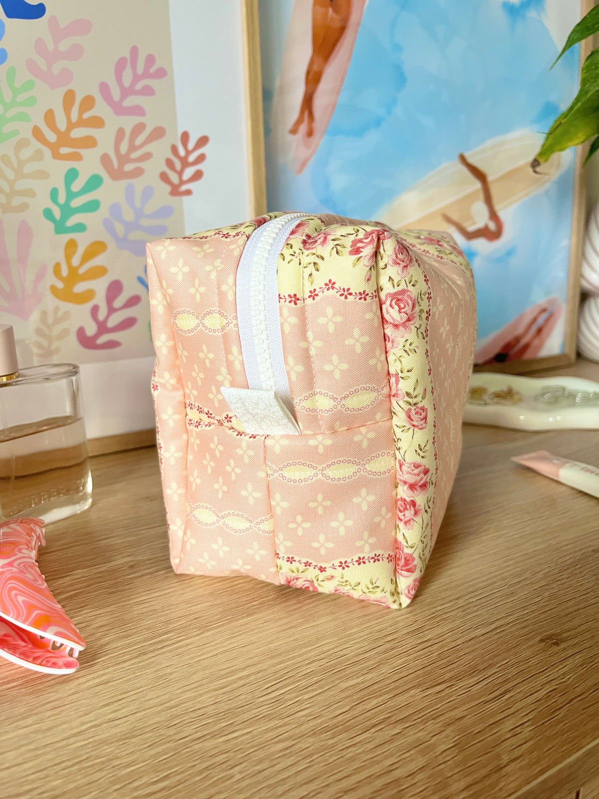 Pink floral medium makeup bag with white handles and zipper