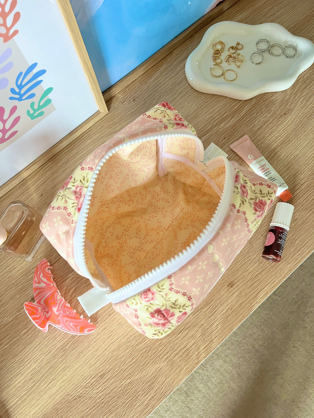Pink floral medium makeup bag open, showing tan interior and white lining