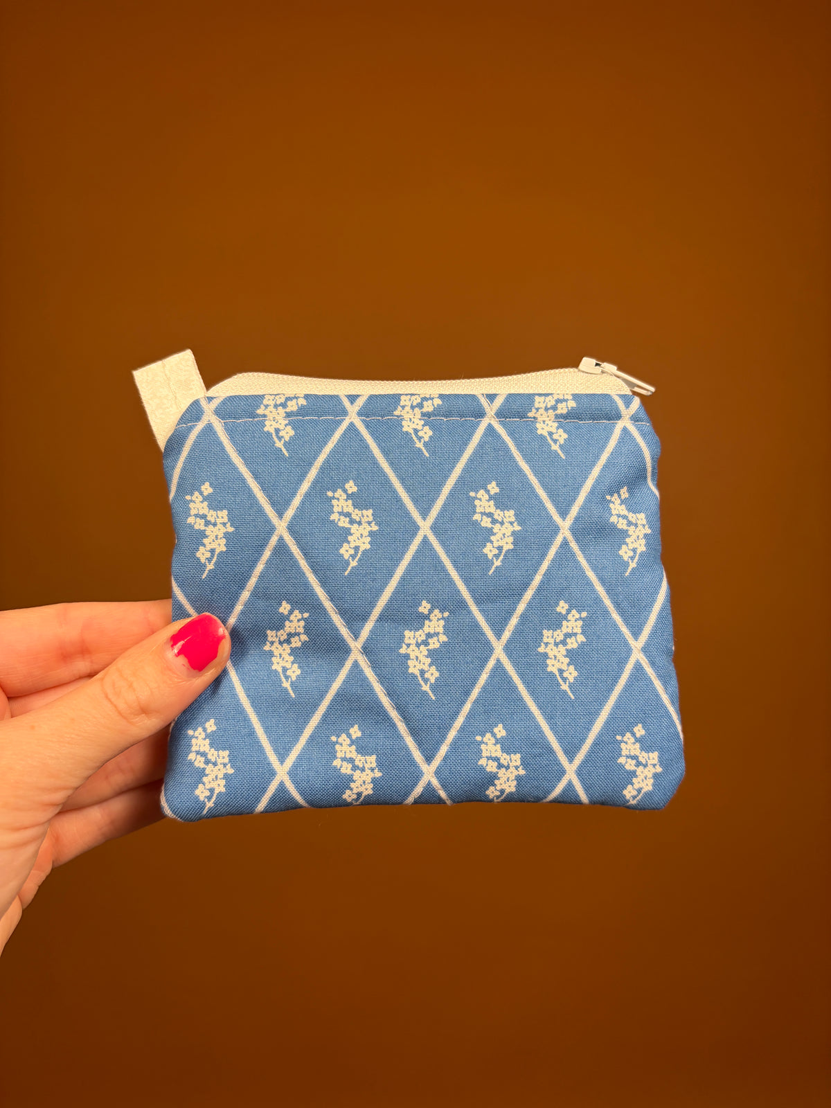 Blue patterned zip keychain wallet with beige tab, side/back view
