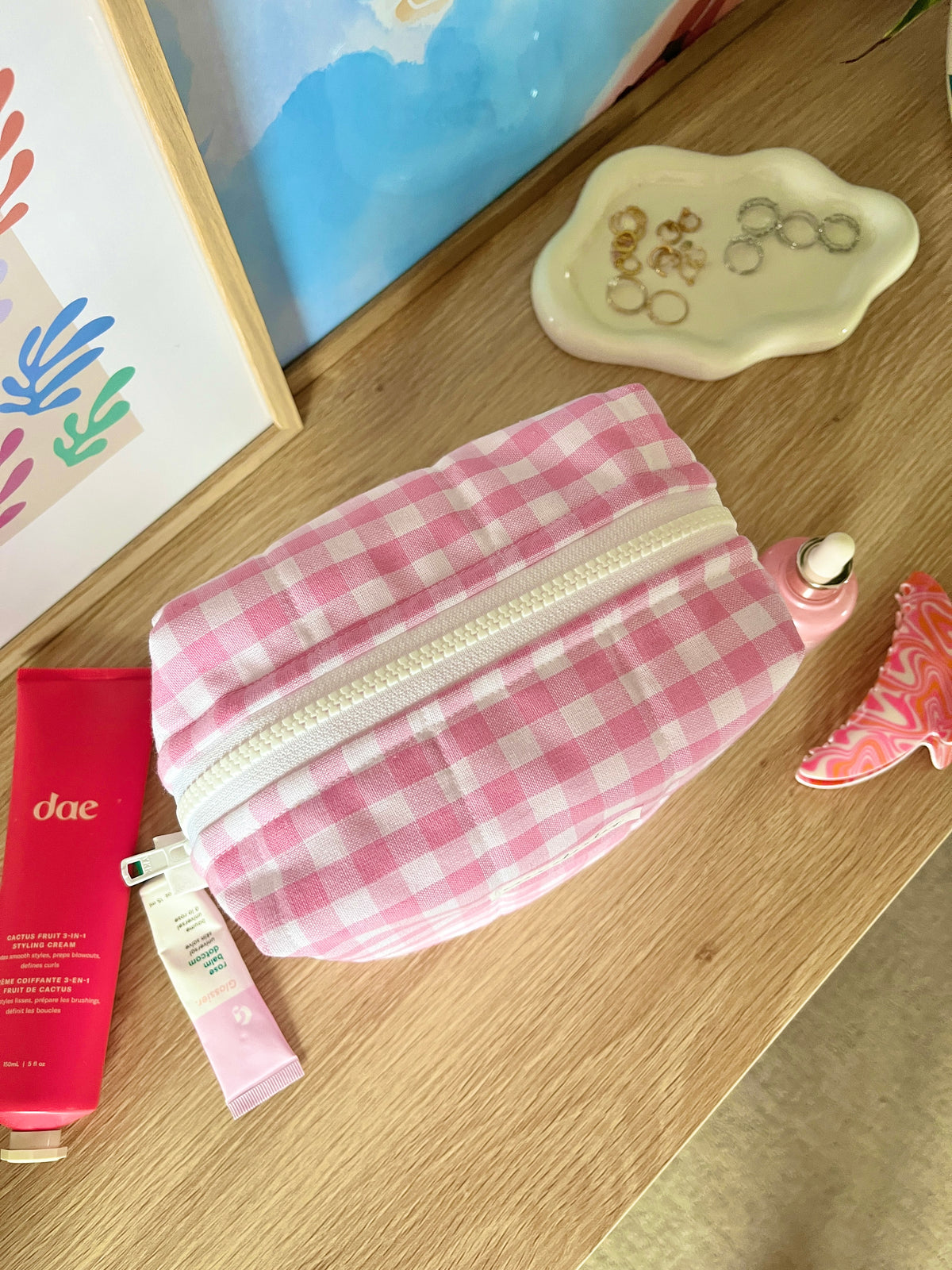 Pink gingham makeup bag side view with silver zipper and stitched trim