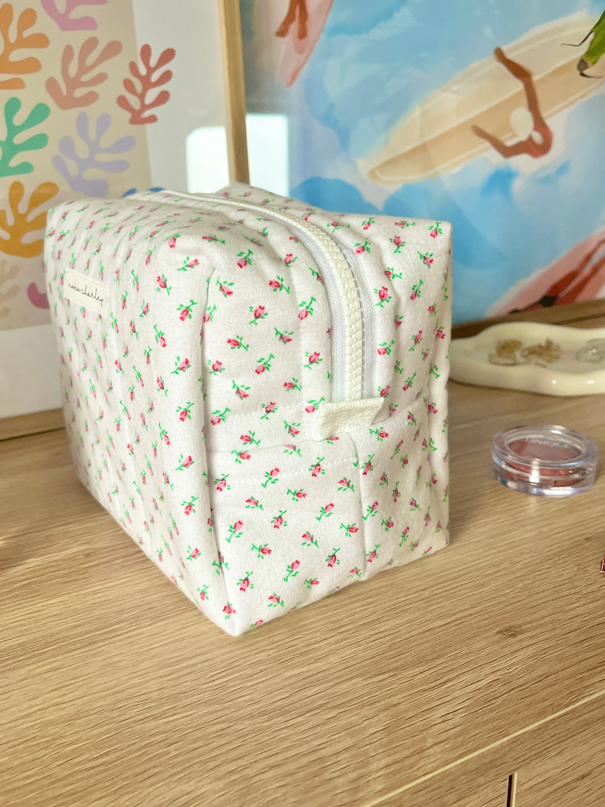 Mini rose makeup bag, white fabric with small green and pink floral print and curved front zipper