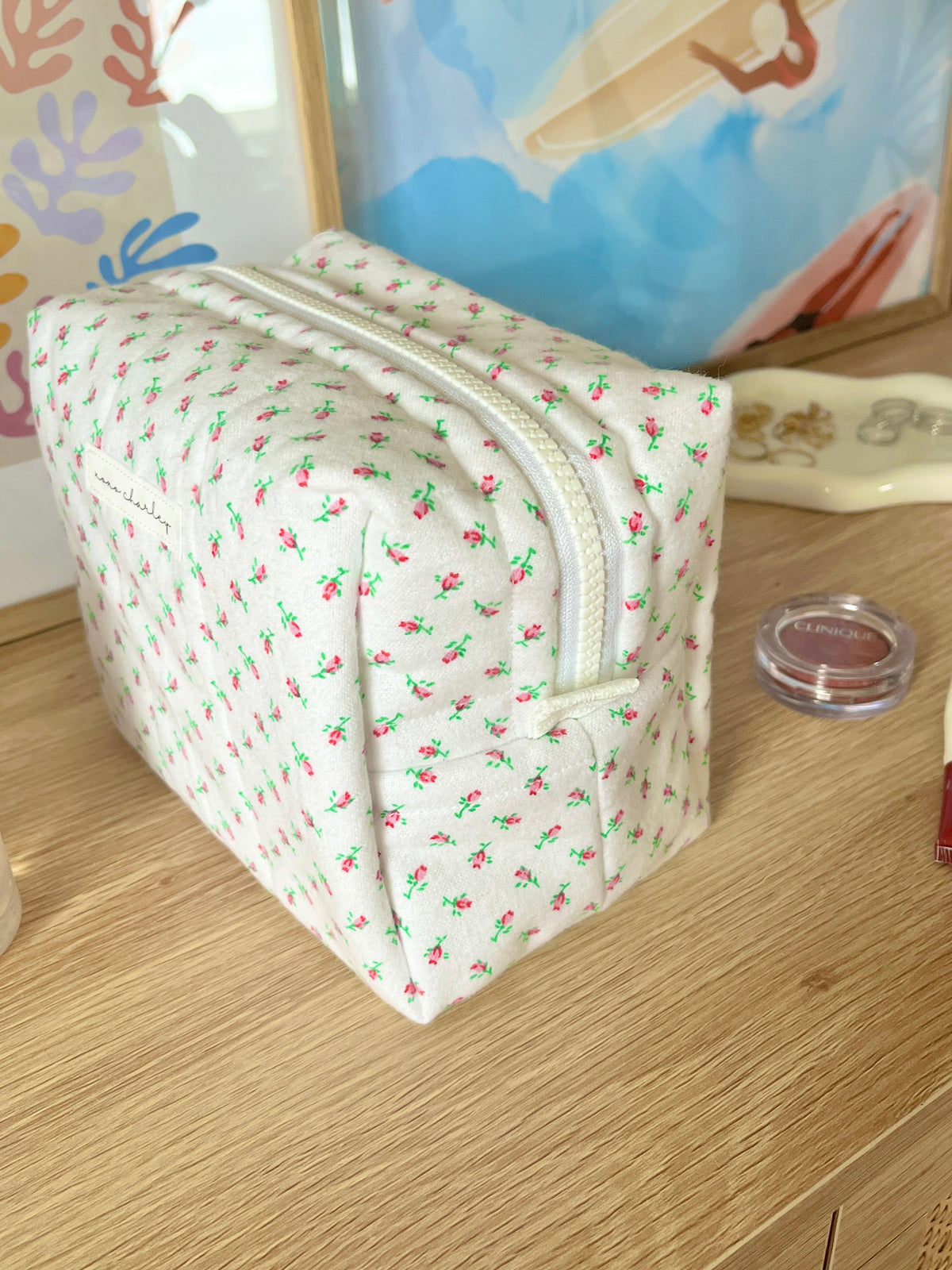 Mini rose medium makeup bag with white floral print and top zip, front view angled