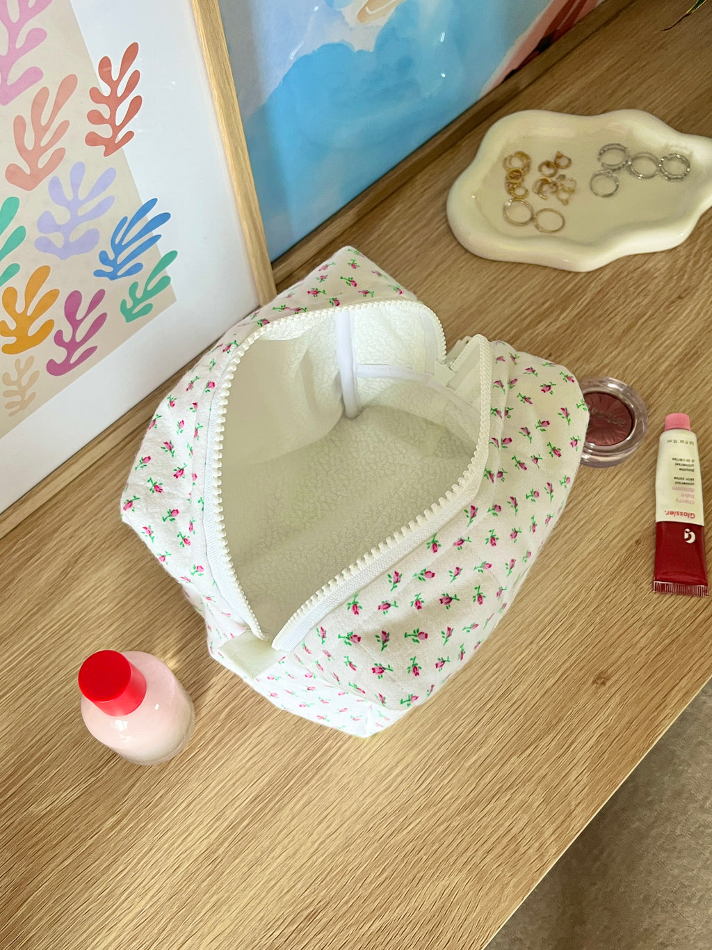 Mini rose medium makeup bag open, white floral print with cream fabric lining and top zipper