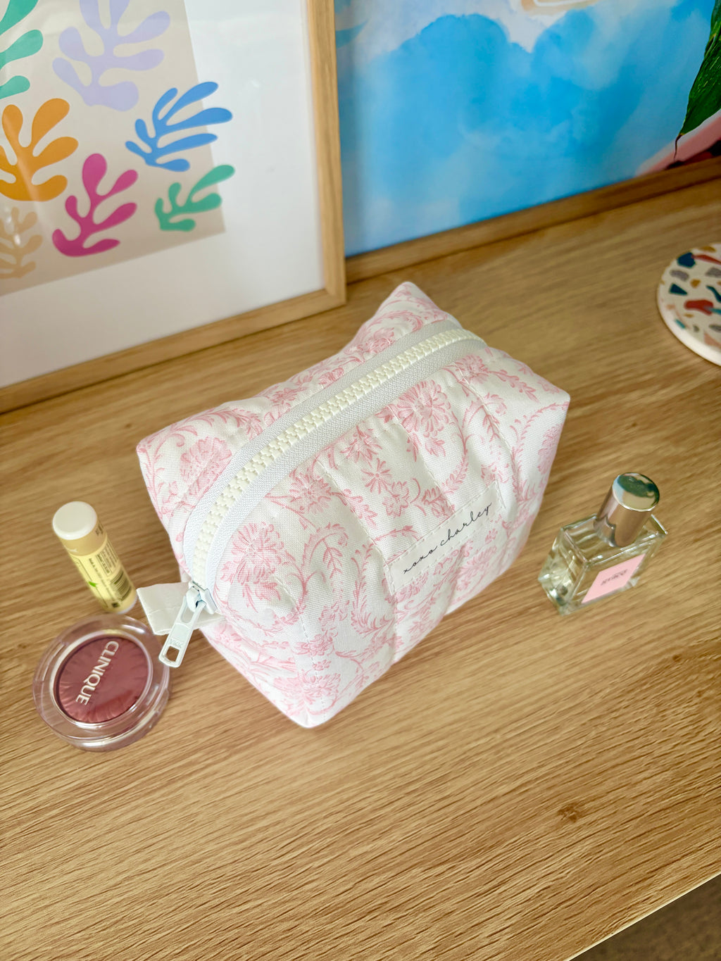 Pink floral mini makeup bag with light-colored zipper tape and strap