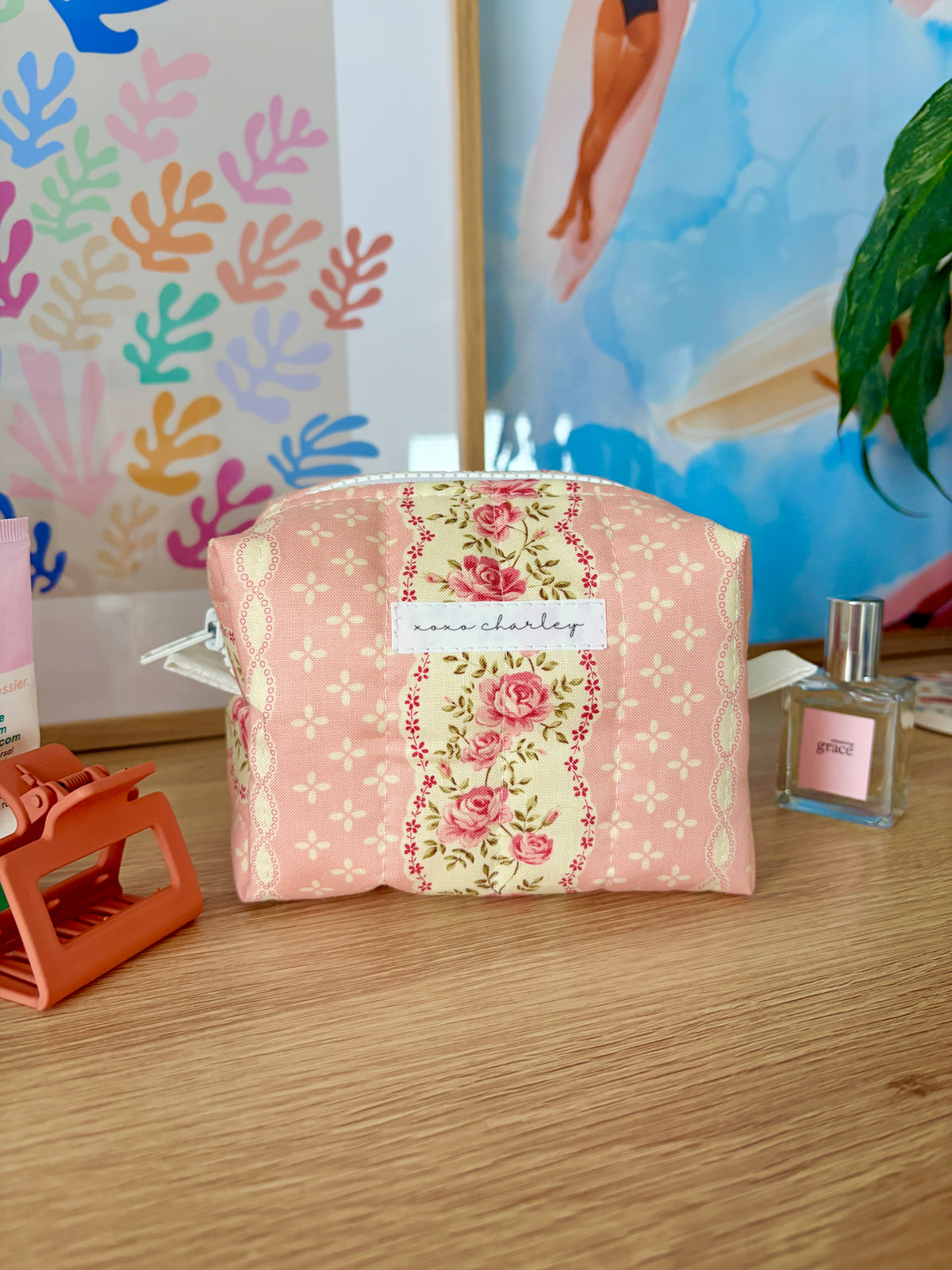 Pink floral mini makeup bag with white zipper trim and top handle