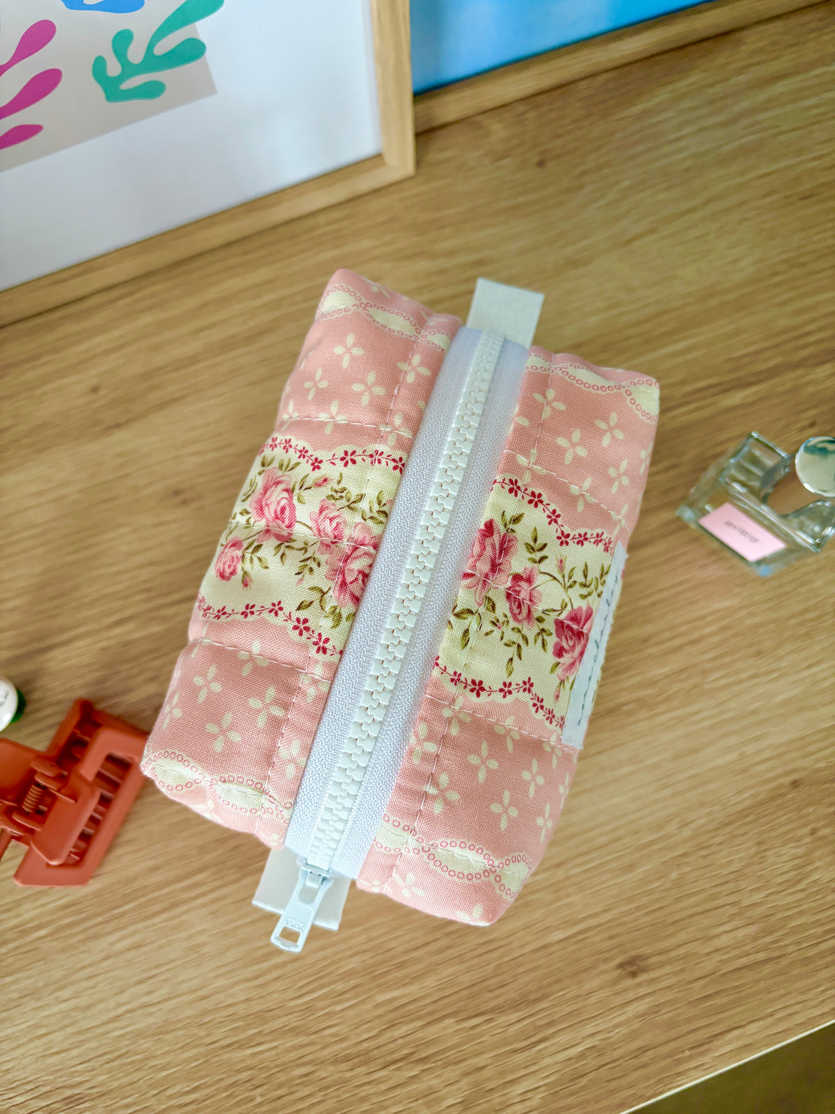Pink floral mini makeup bag with white zipper, small hanging tag