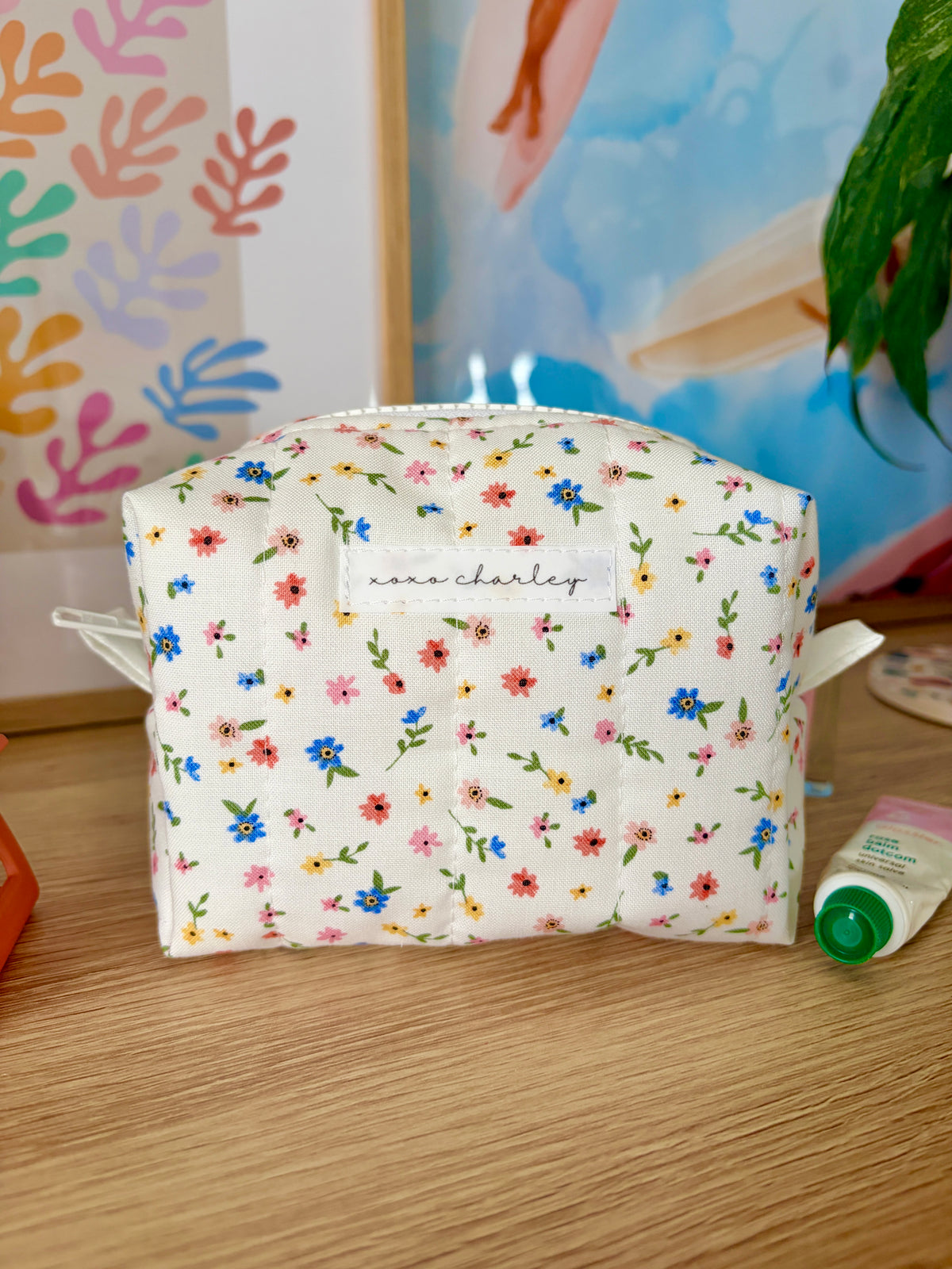 Mini white makeup bag with colorful flower print and top zipper