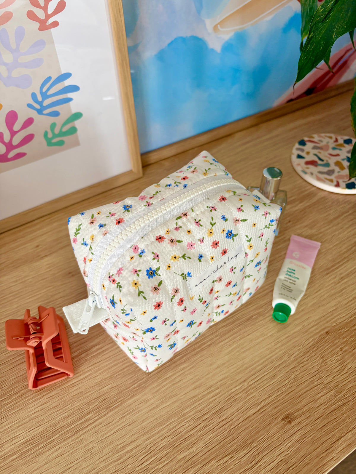 Mini floral makeup bag with white zipper and rounded top shape