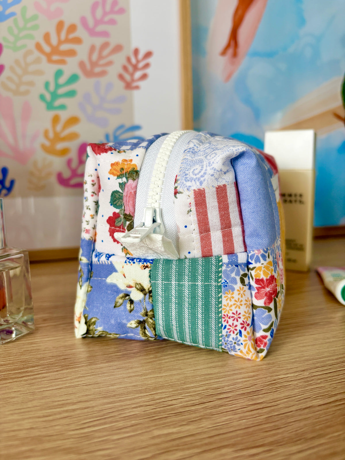 Patchwork mini makeup bag with folded strap, floral and striped fabric, side view