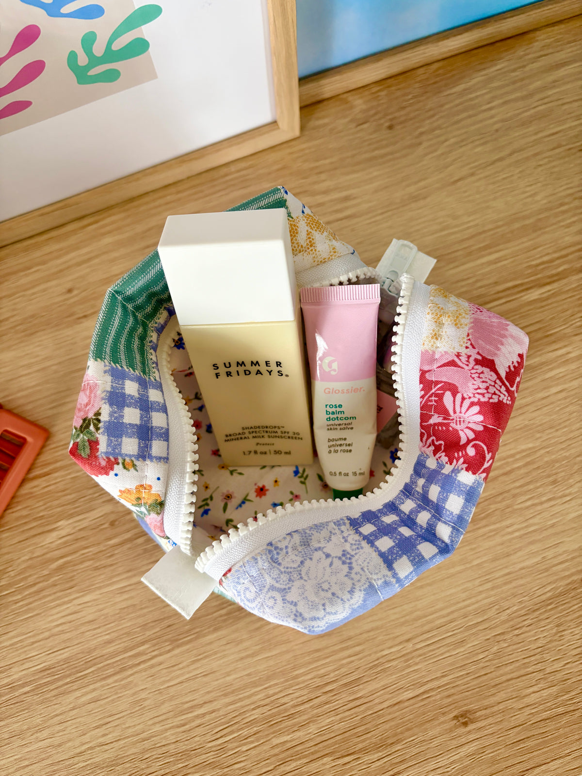 Mini makeup bag with assorted cosmetics, patchwork panels and lace-trim zipper opening