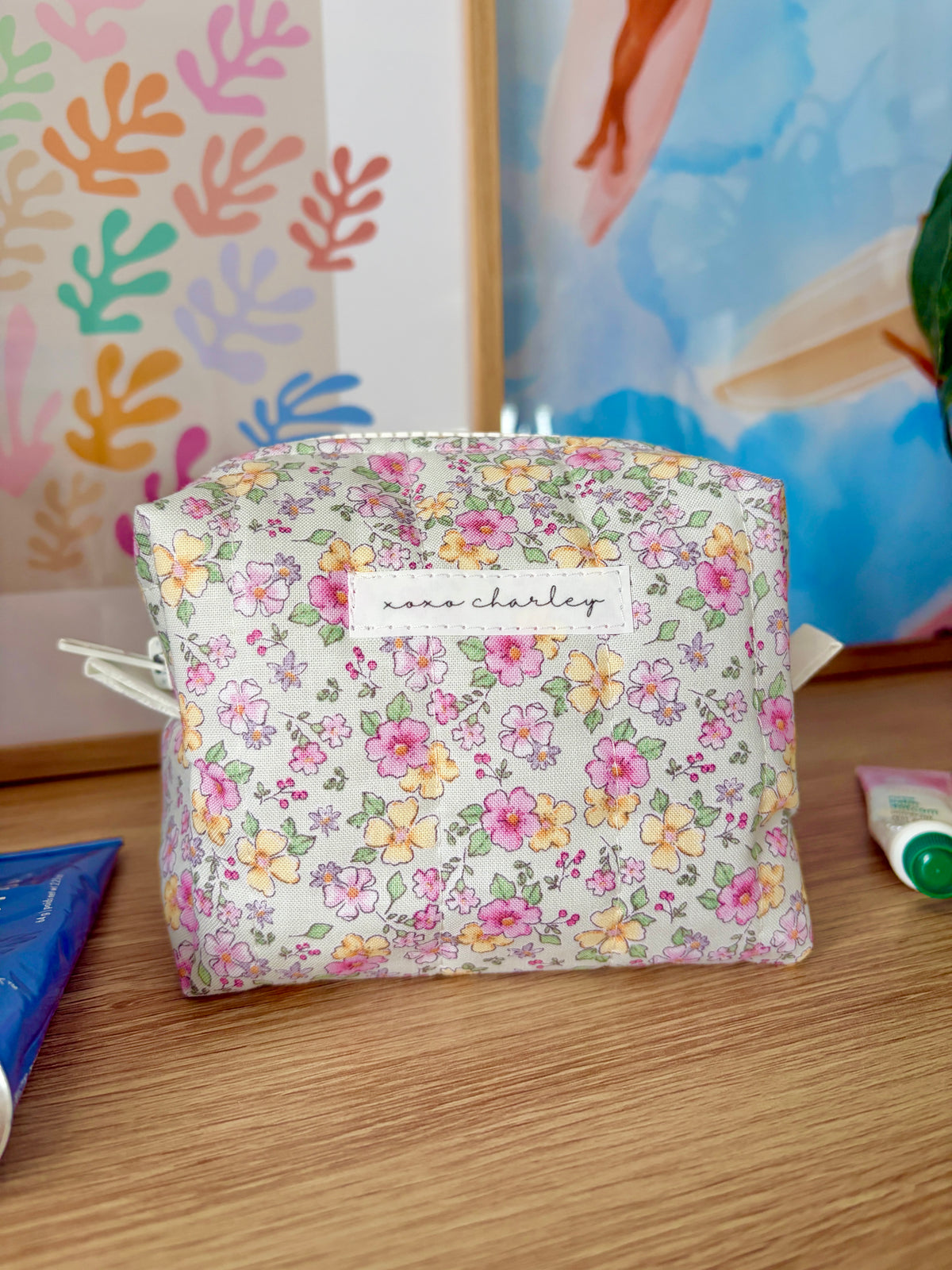 Floral mini makeup bag with zip-top; white base with pink, yellow, and green flowers.