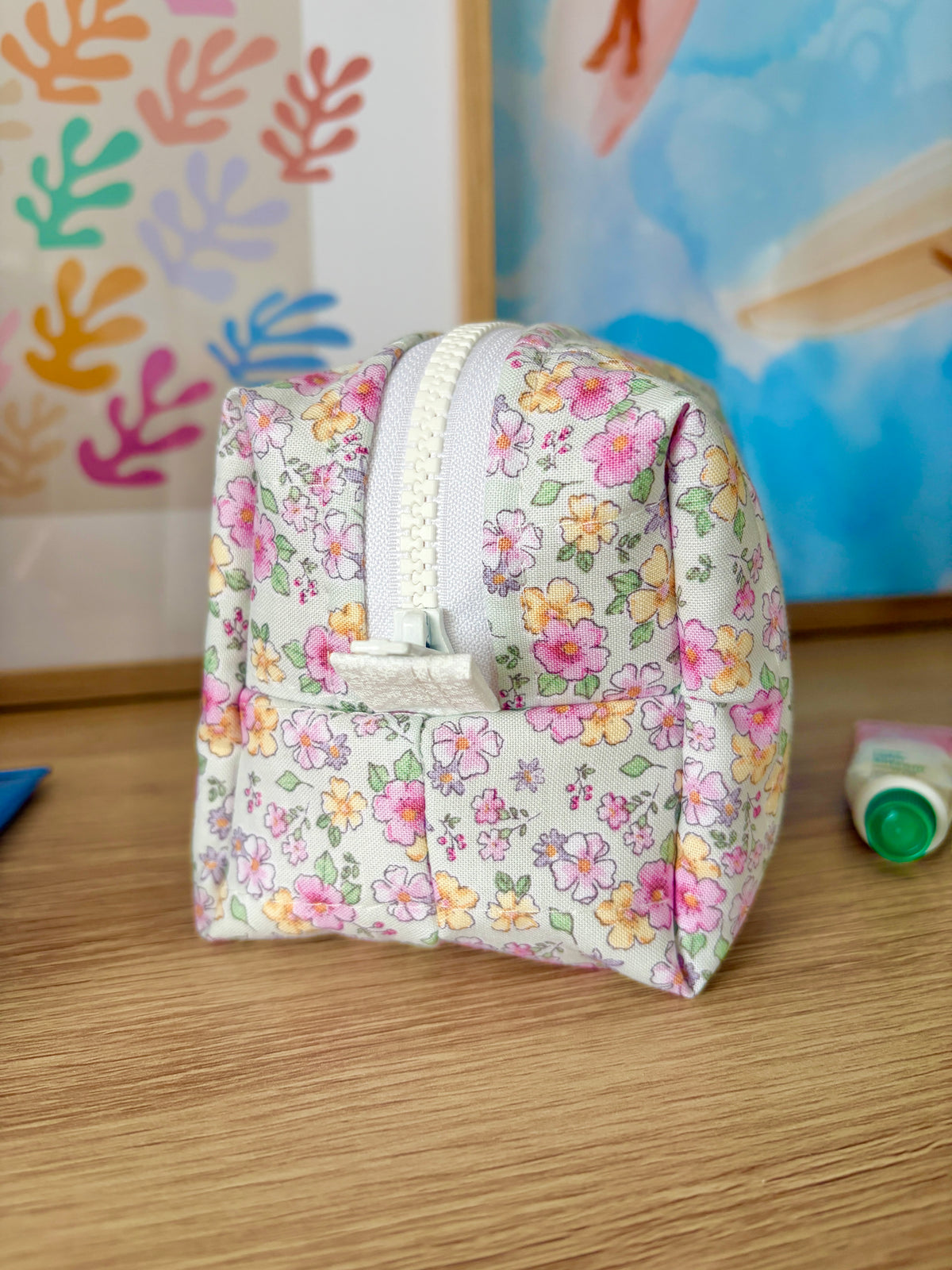 Floral mini makeup bag with zip-top and carry loop; white with multicolor flower print.