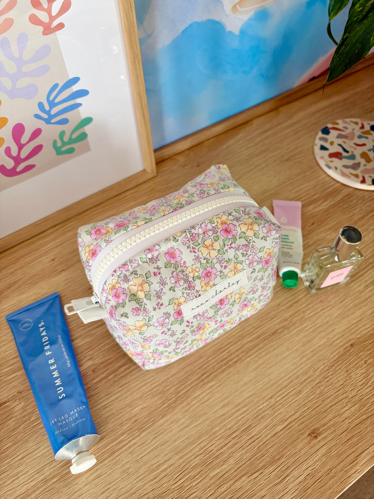 Floral mini makeup bag, zip-top; white fabric with multicolor floral print.