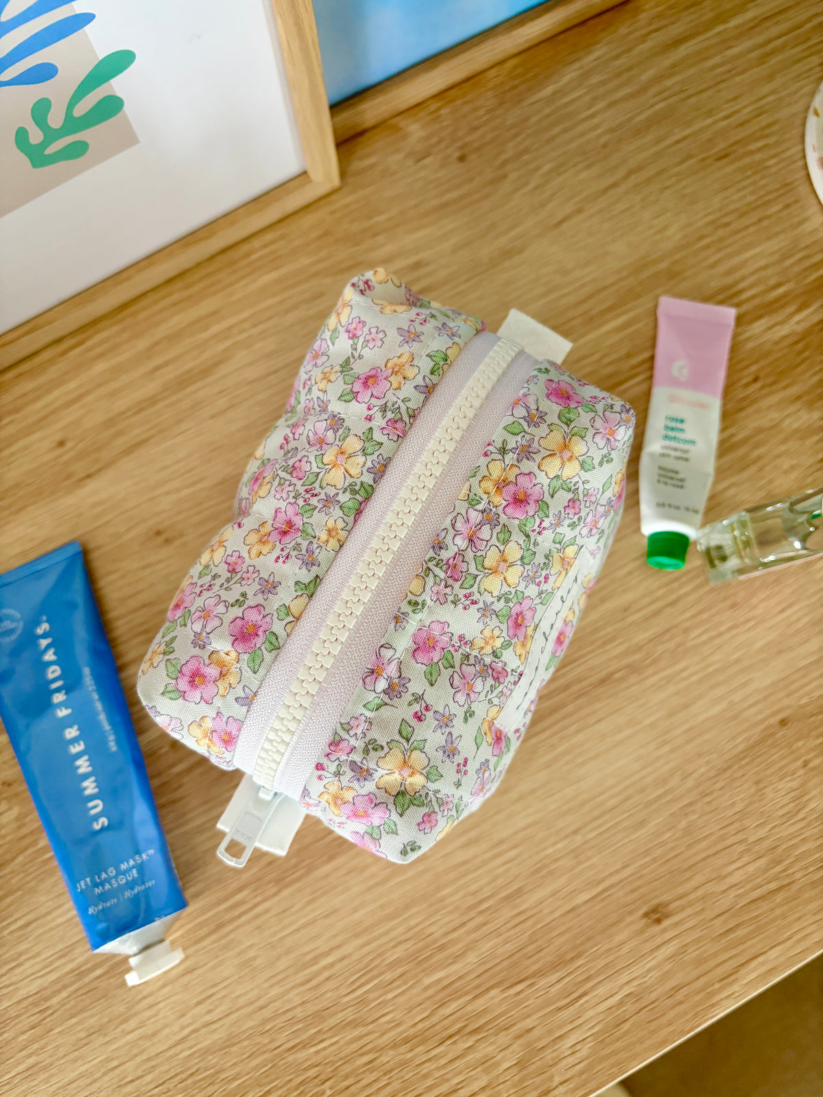 Floral mini makeup bag with zip-top; white with multicolor floral print.