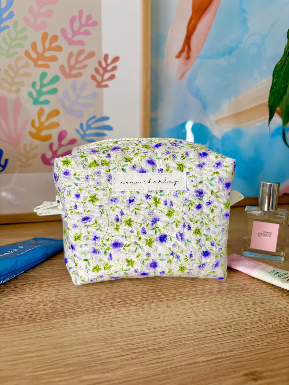 Mini floral makeup bag, white with purple and green flowers; zip-top closure