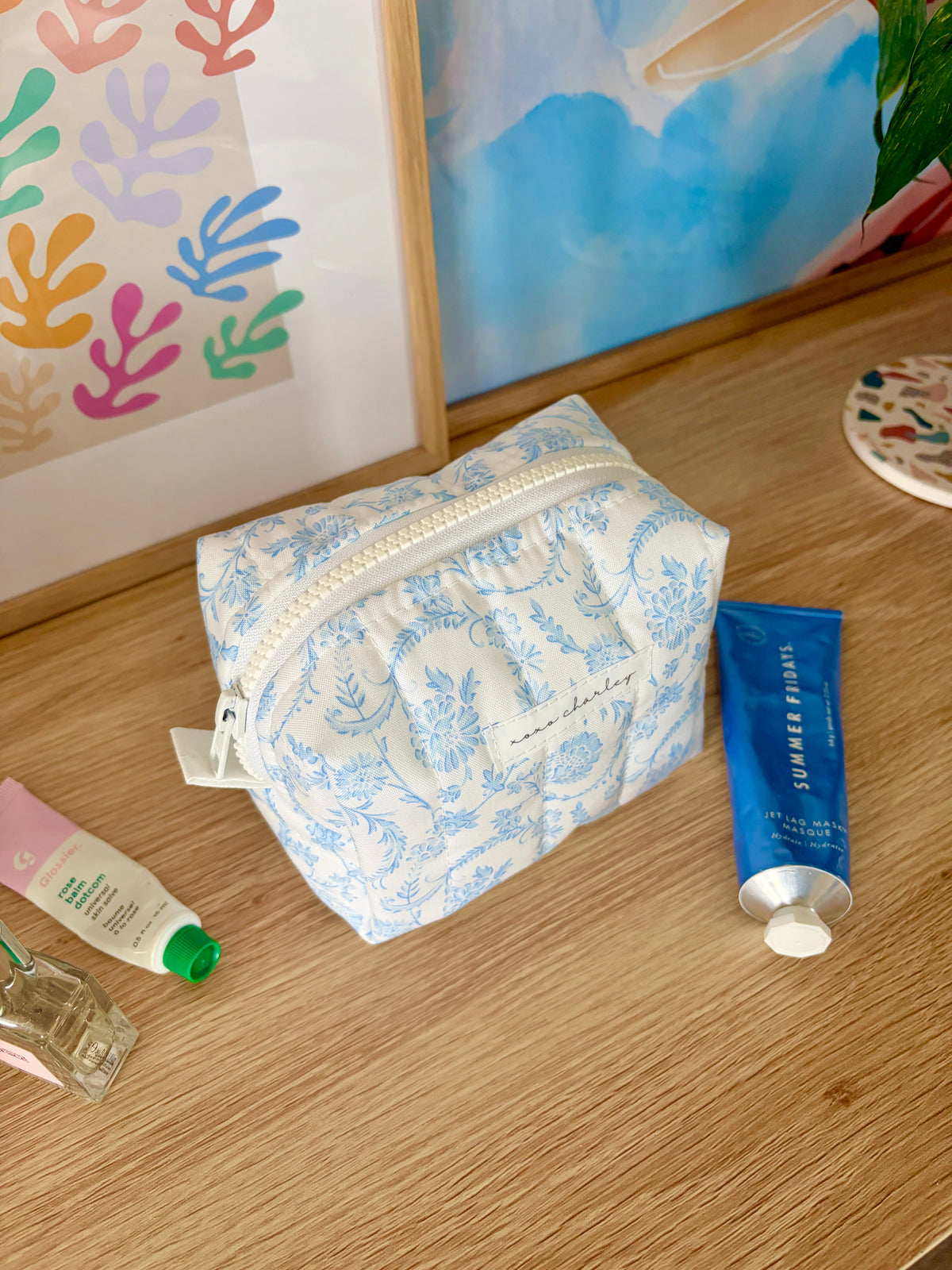 Vintage blue mini makeup bag with white zipper and blue floral print, compact rectangular shape.