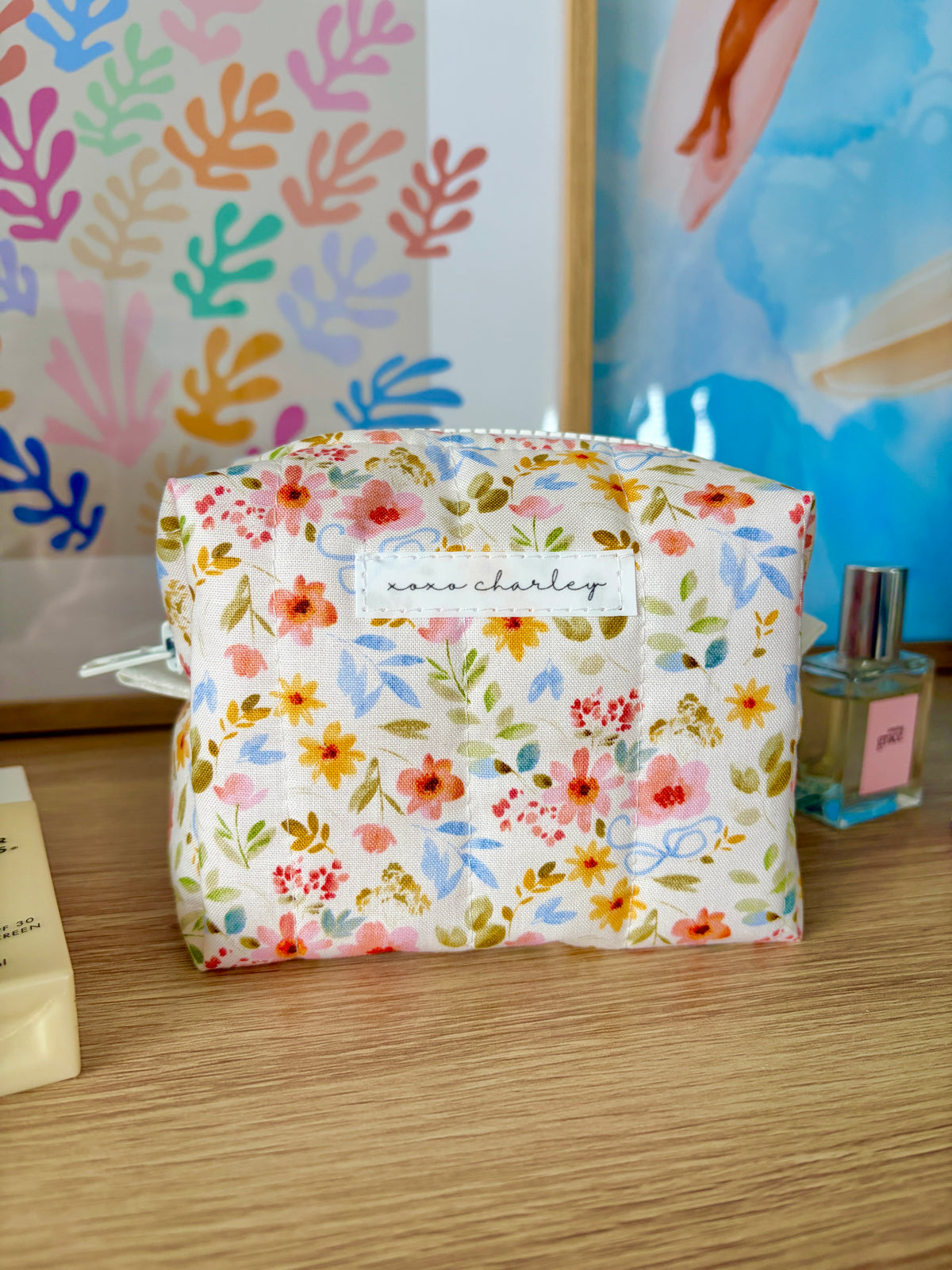 Bright floral mini makeup bag with white zipper, rounded shape, lined interior