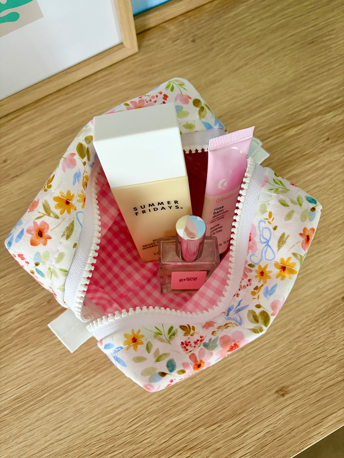 Bright floral mini makeup bag open, rounded pouch with pink gingham lining